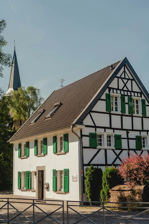 Casa enxaimel com torre de igreja ao fundo