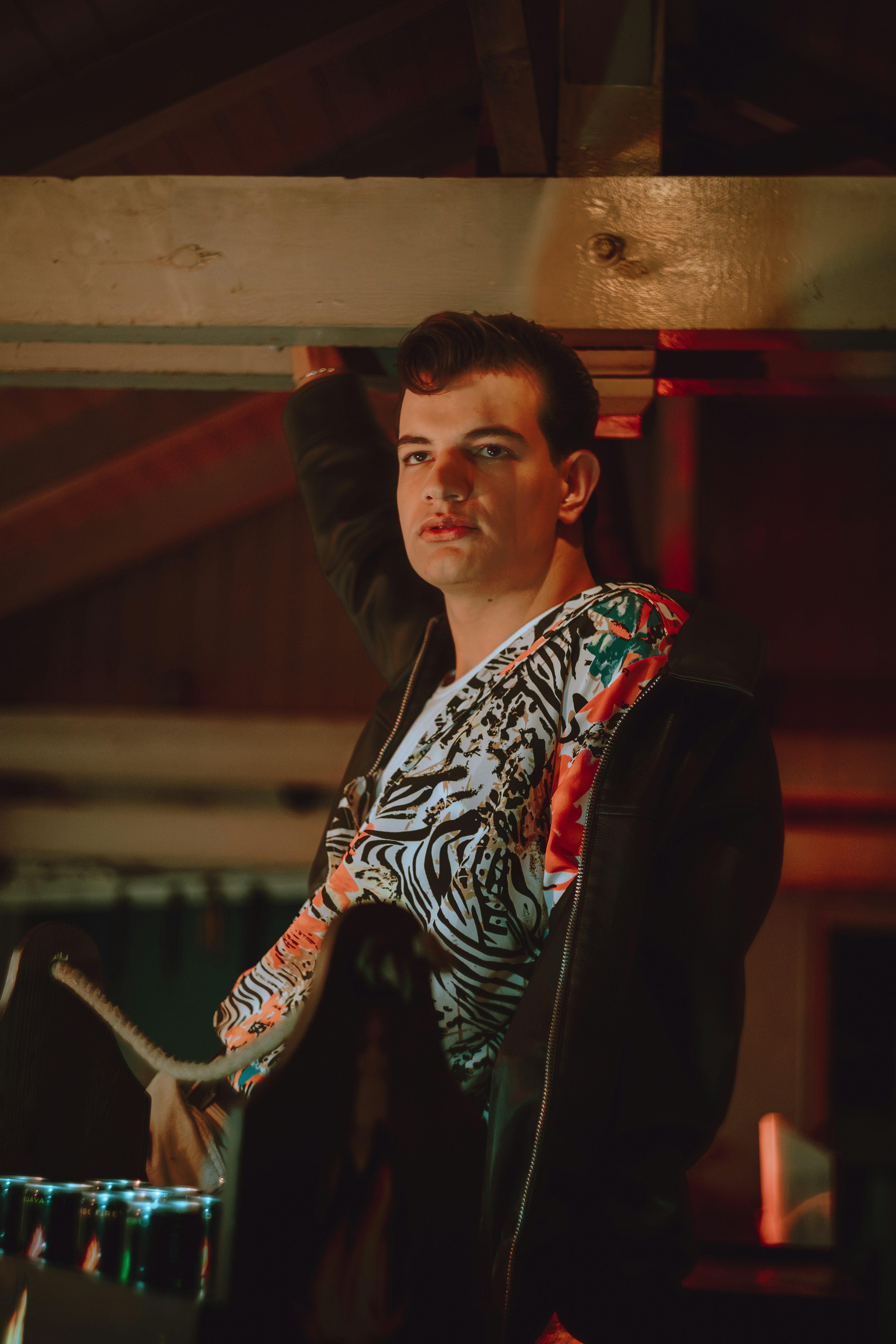 A young man wearing a tiger print shirt and jacket.