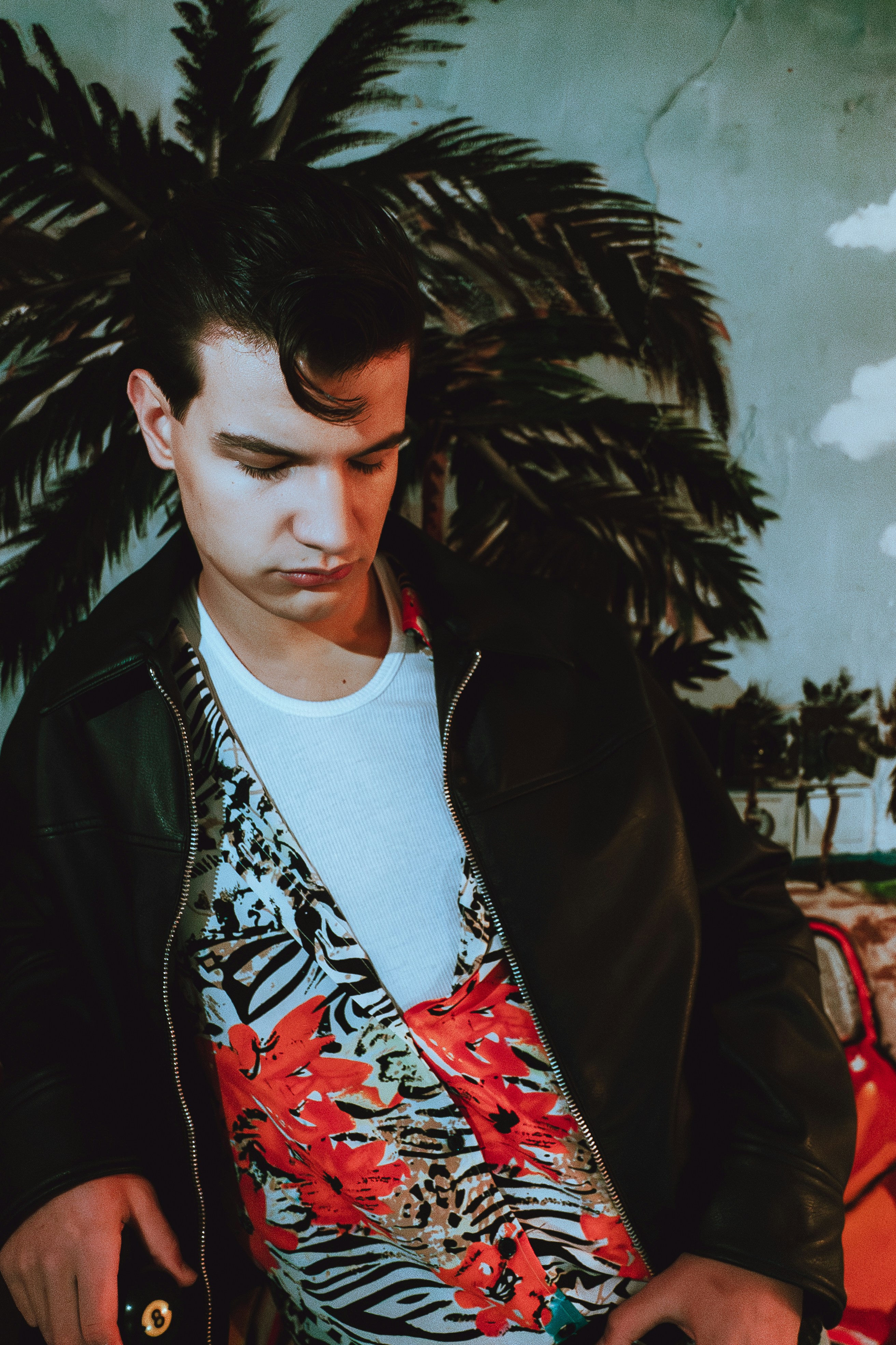 Young man in retro clothing with tropical mural background