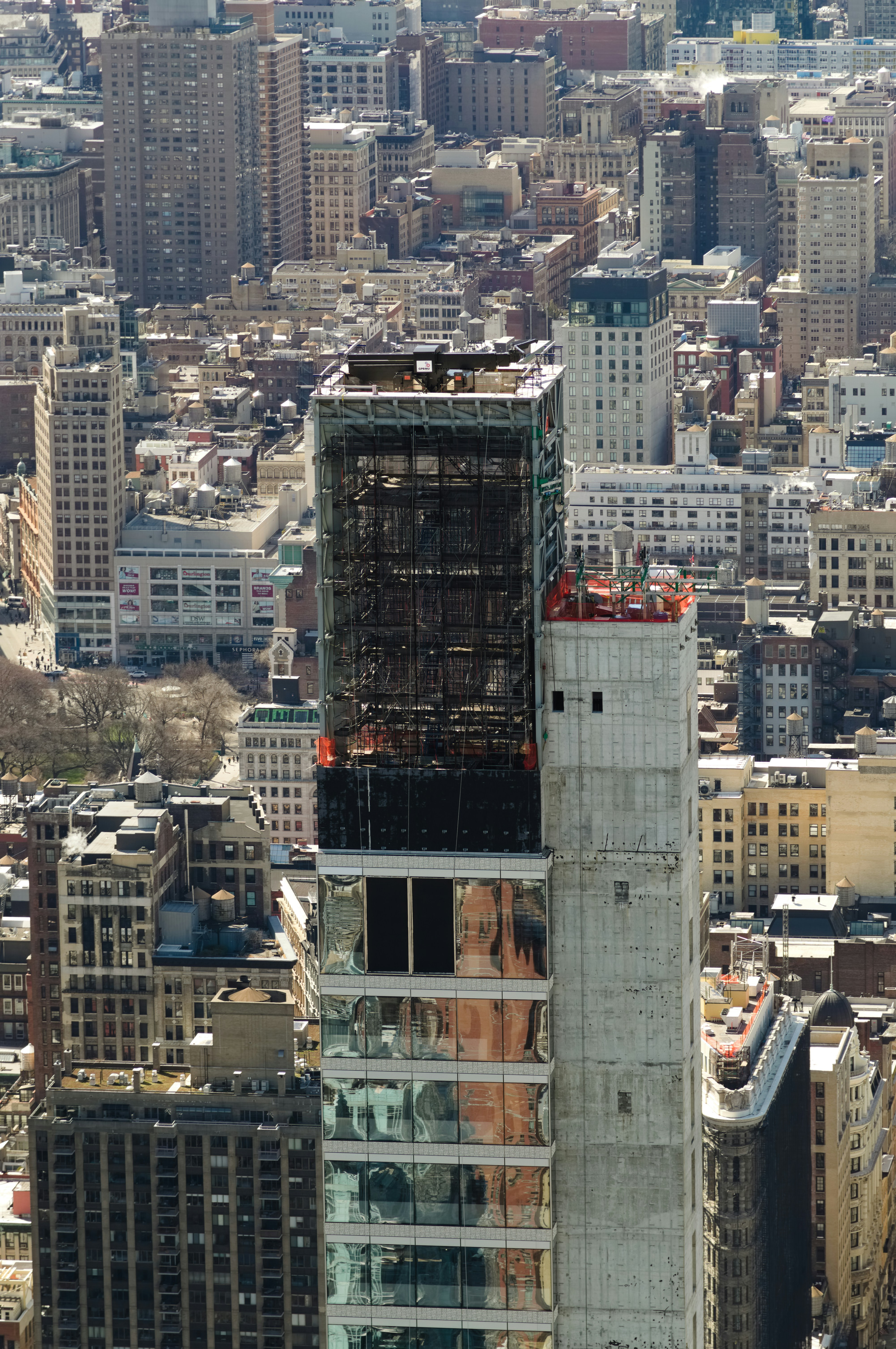 Skyscraper under construction amidst city buildings