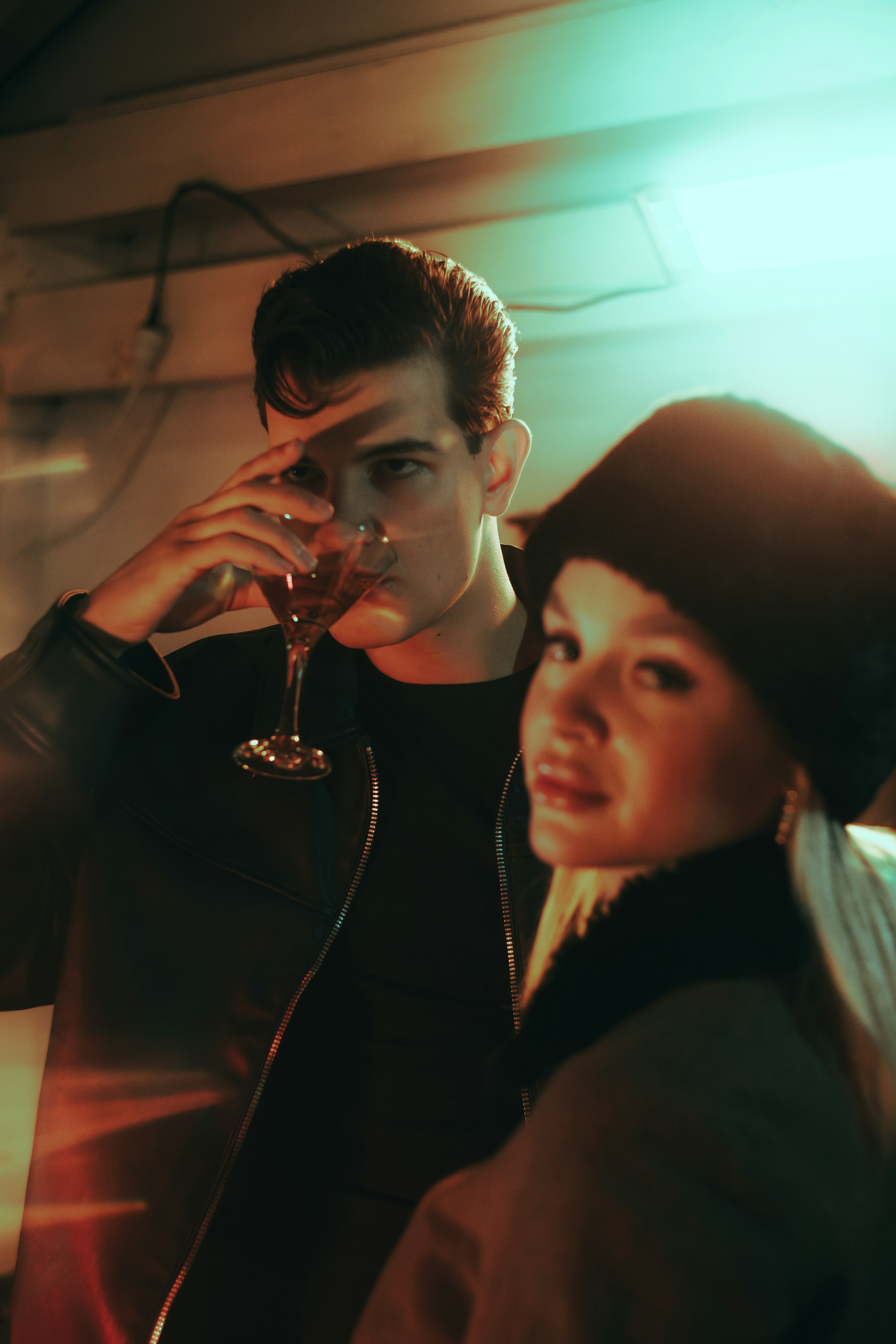 Couple enjoying drinks in moody, colorful lighting