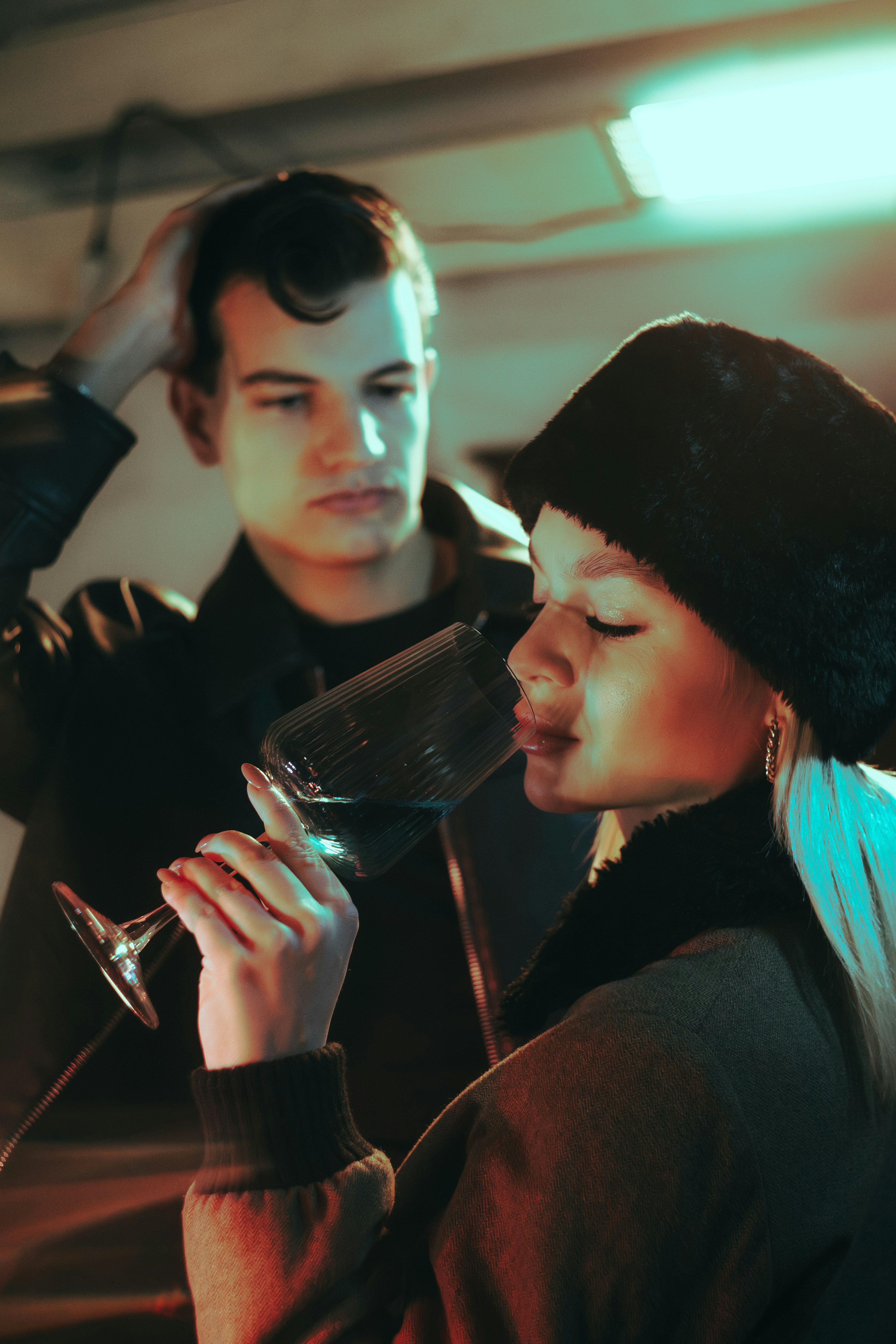 Woman smells wine with man behind her