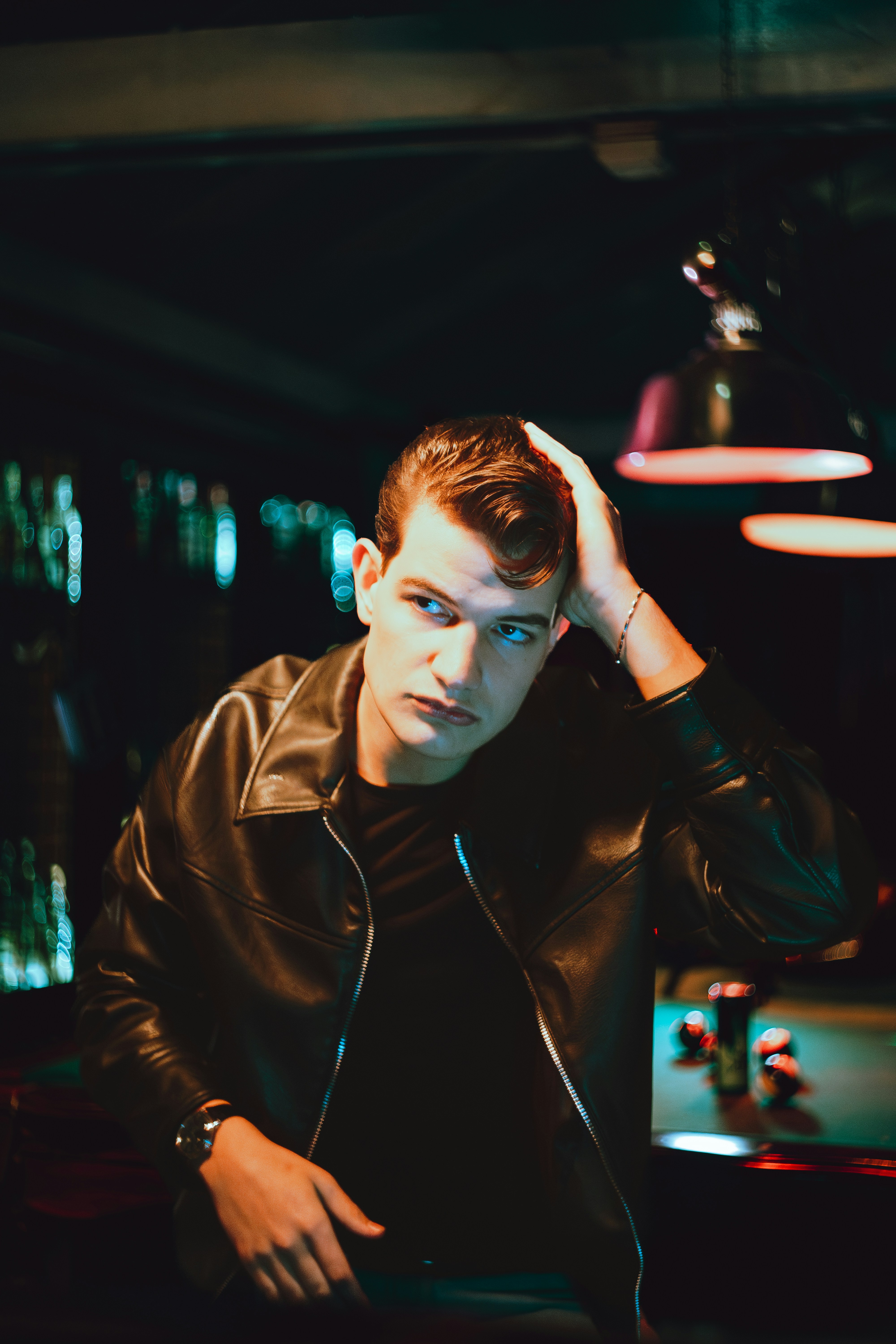 Young man in leather jacket touching his hair