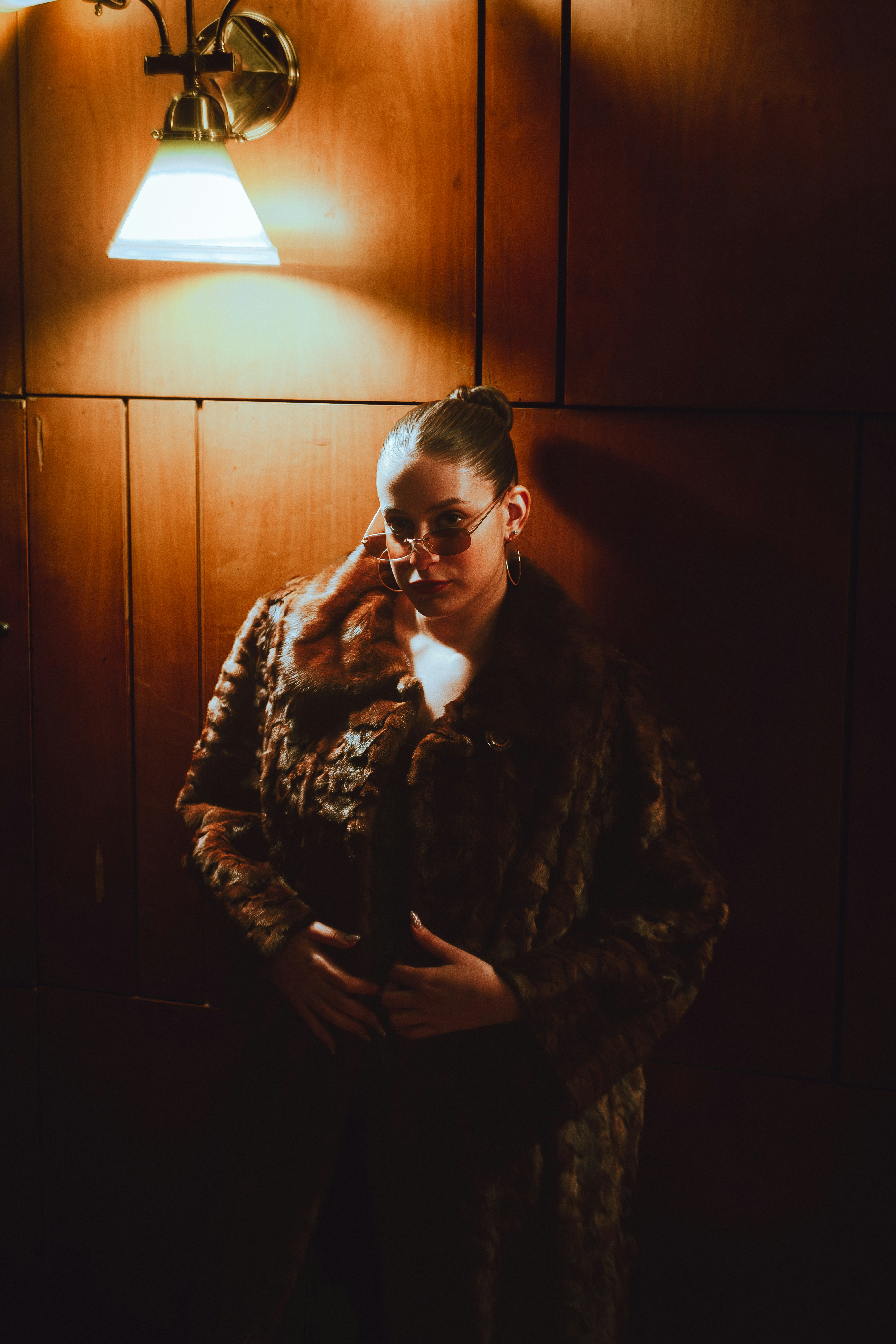 Woman in fur coat under a lamp