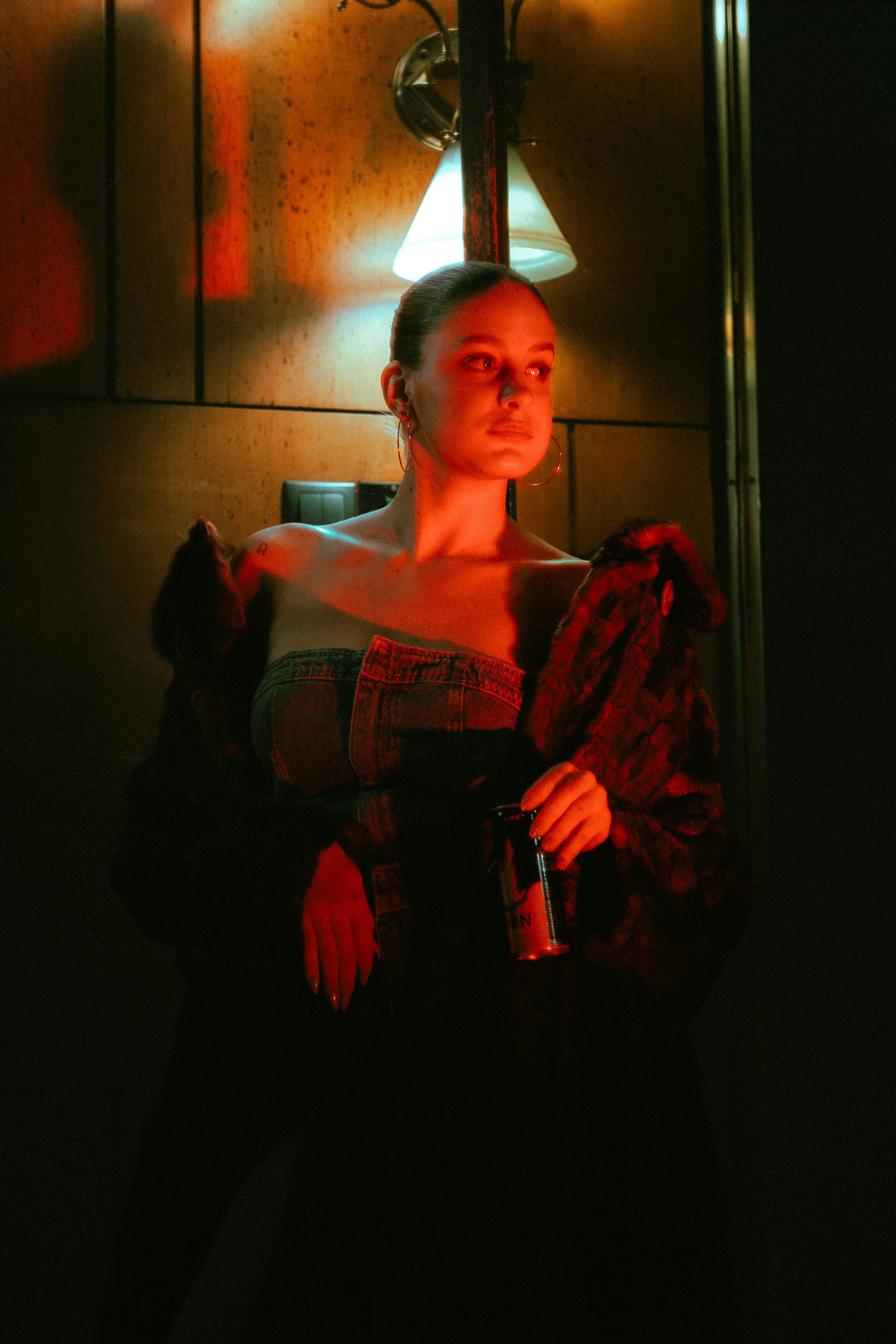Woman in dark room holding a can