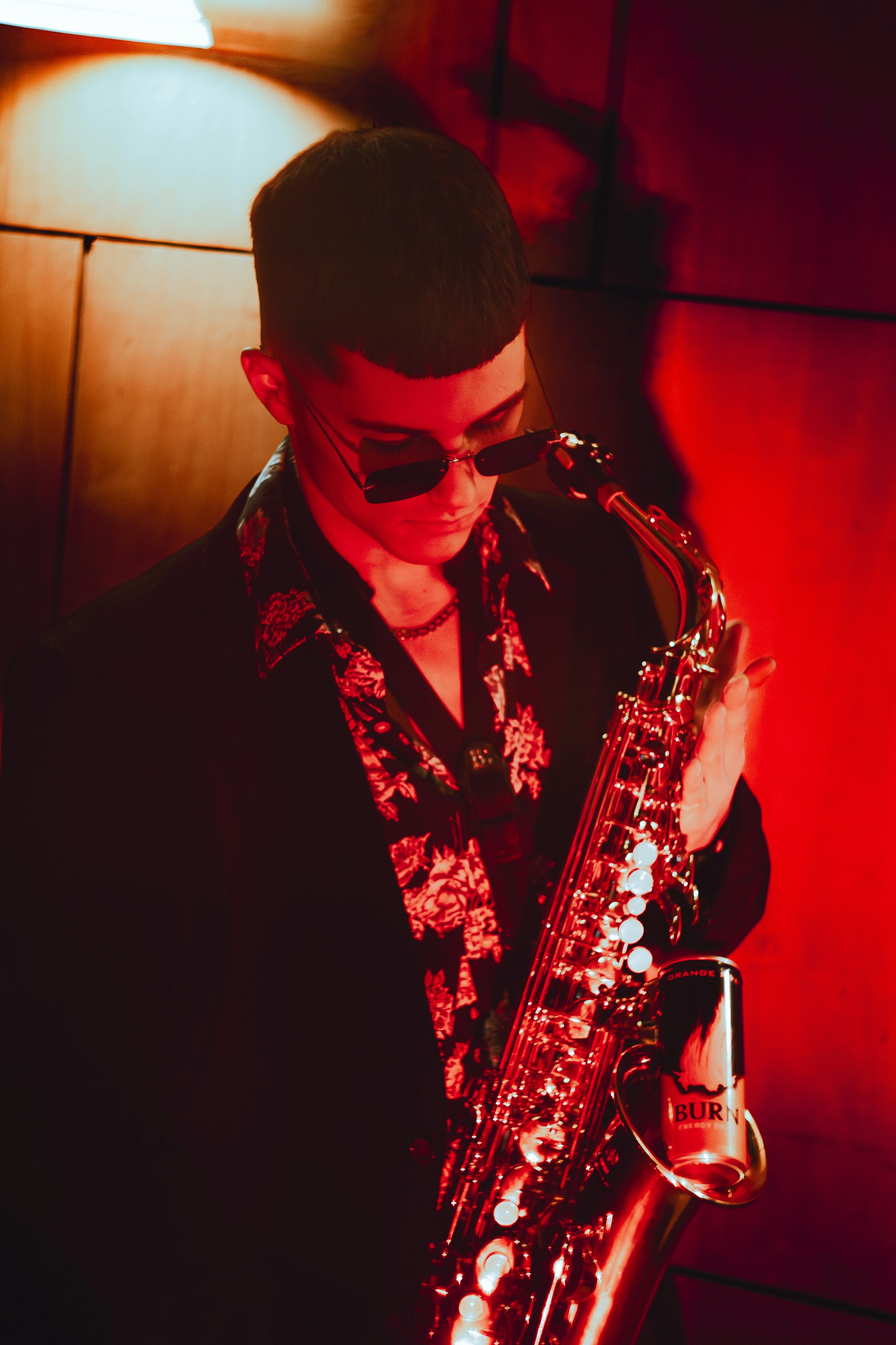 Man in sunglasses playing a saxophone