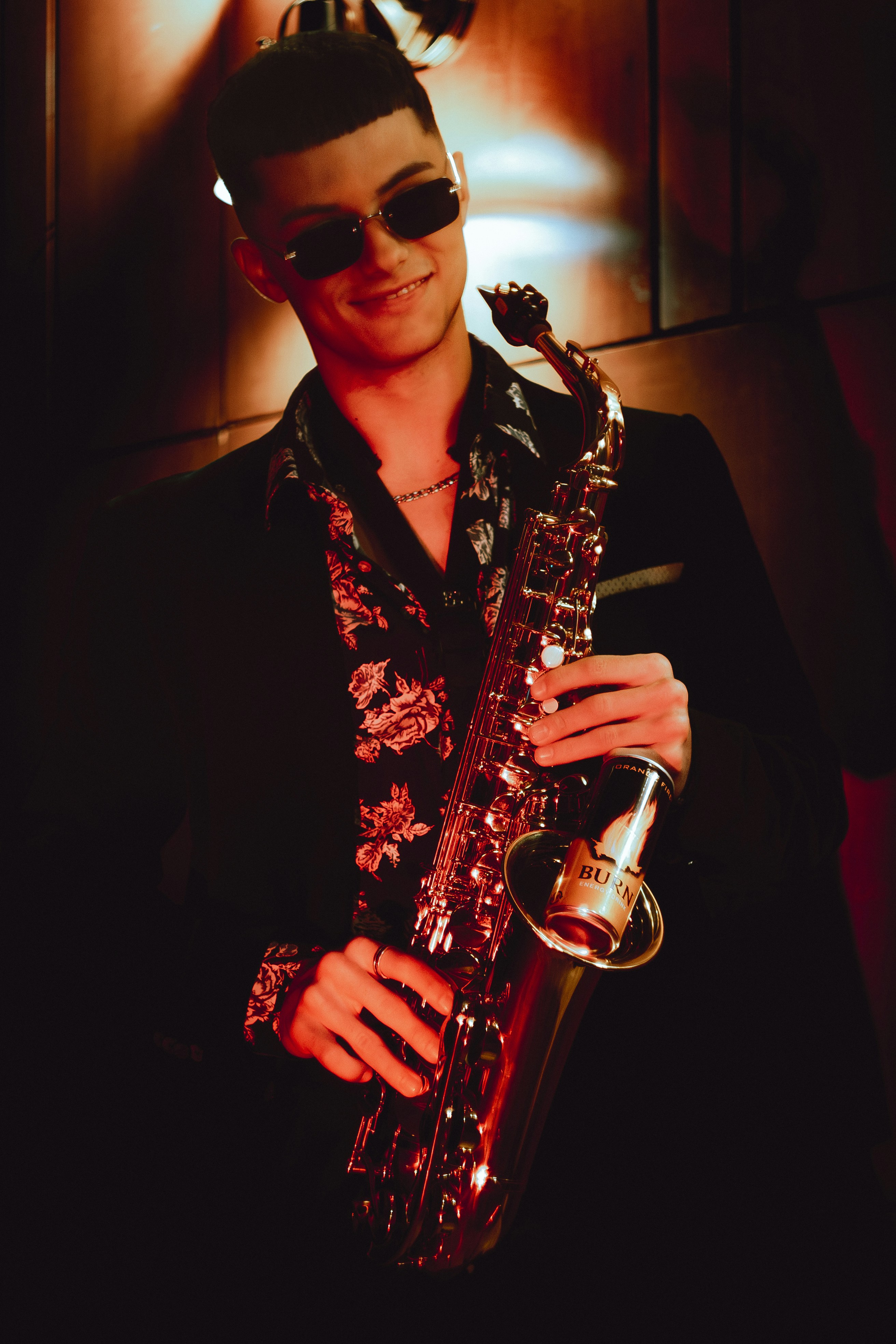 Young man in sunglasses holding a saxophone