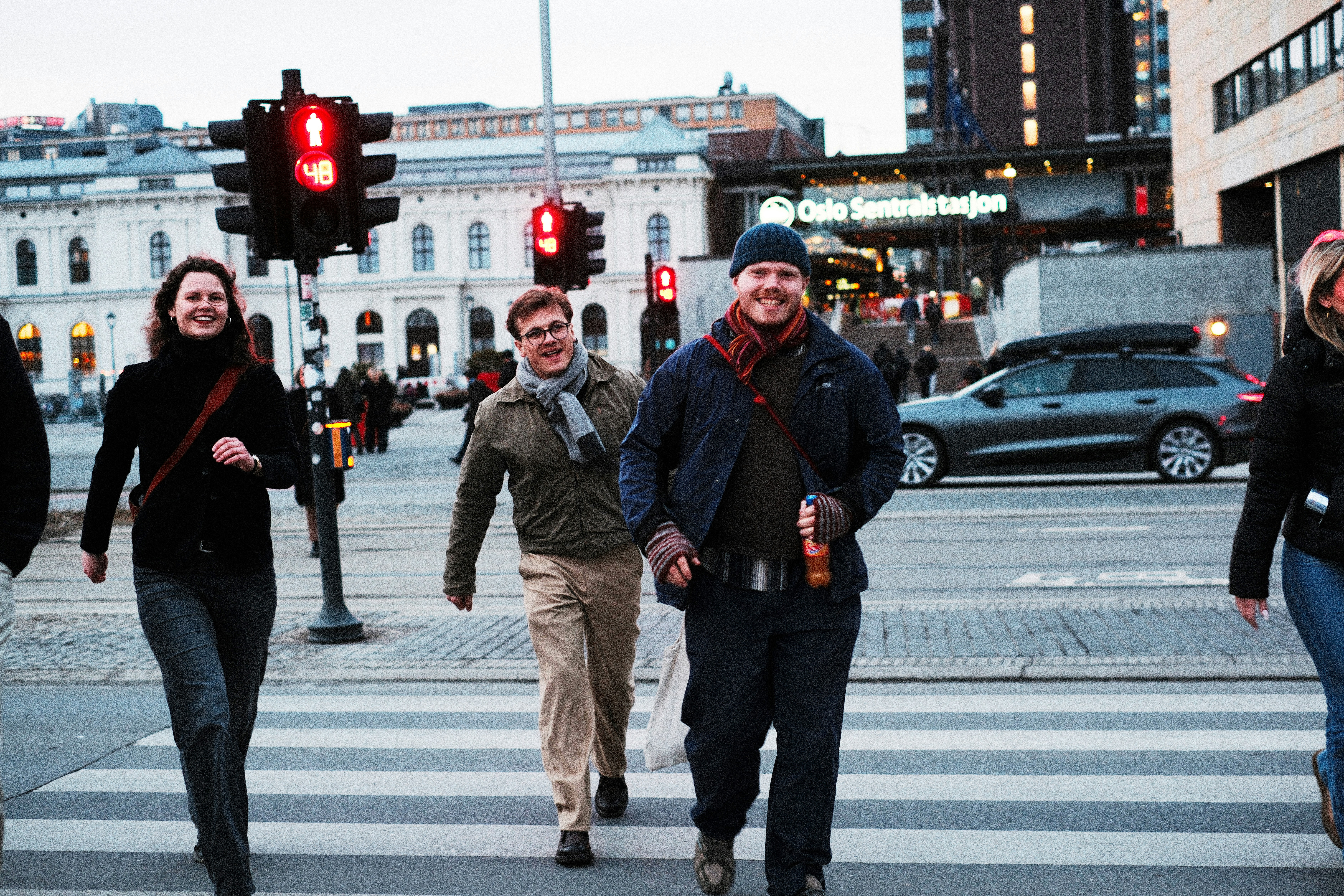people crossing a street with traffic lights