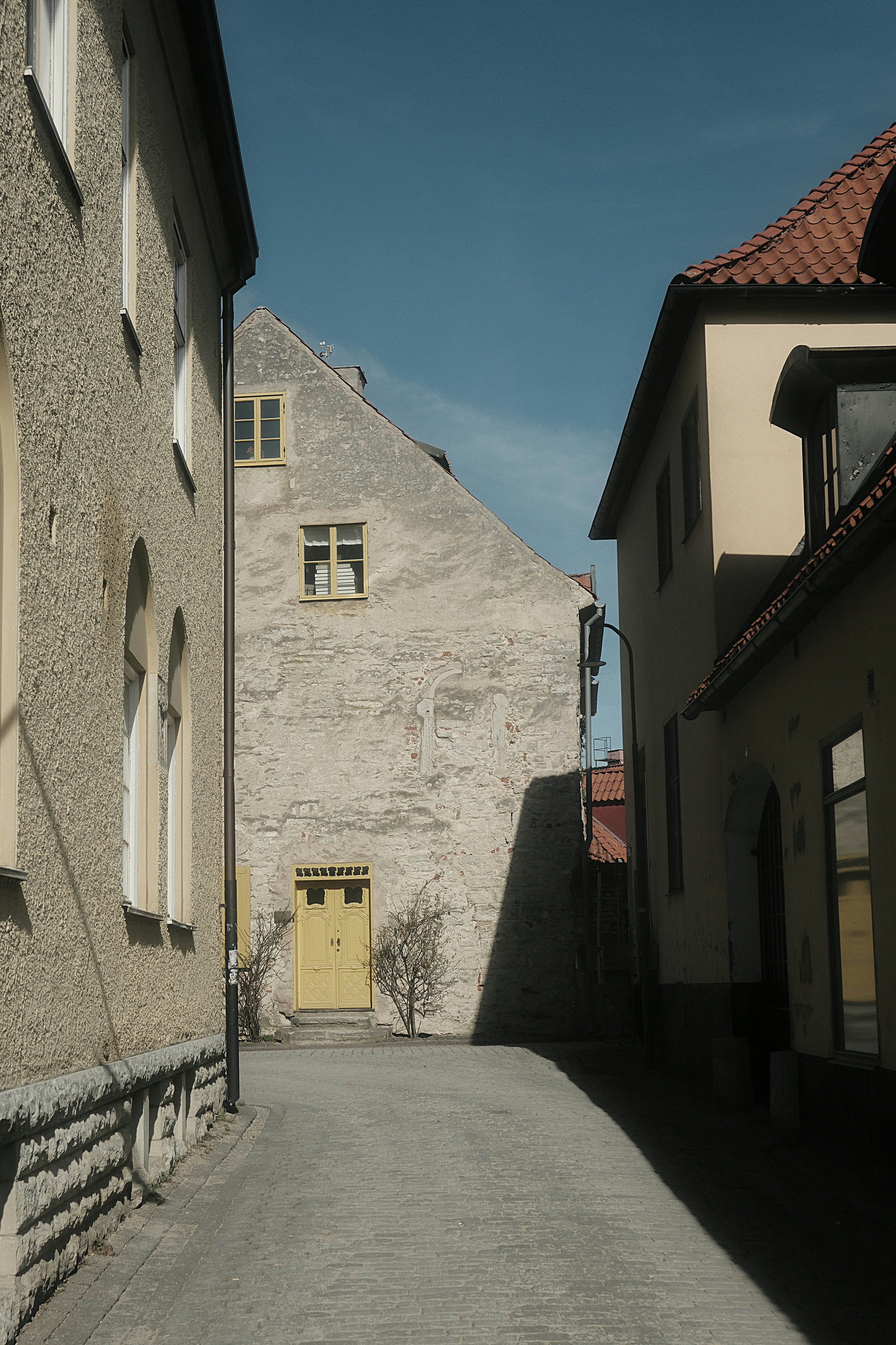Narrow alleyway between old buildings with a yellow door.