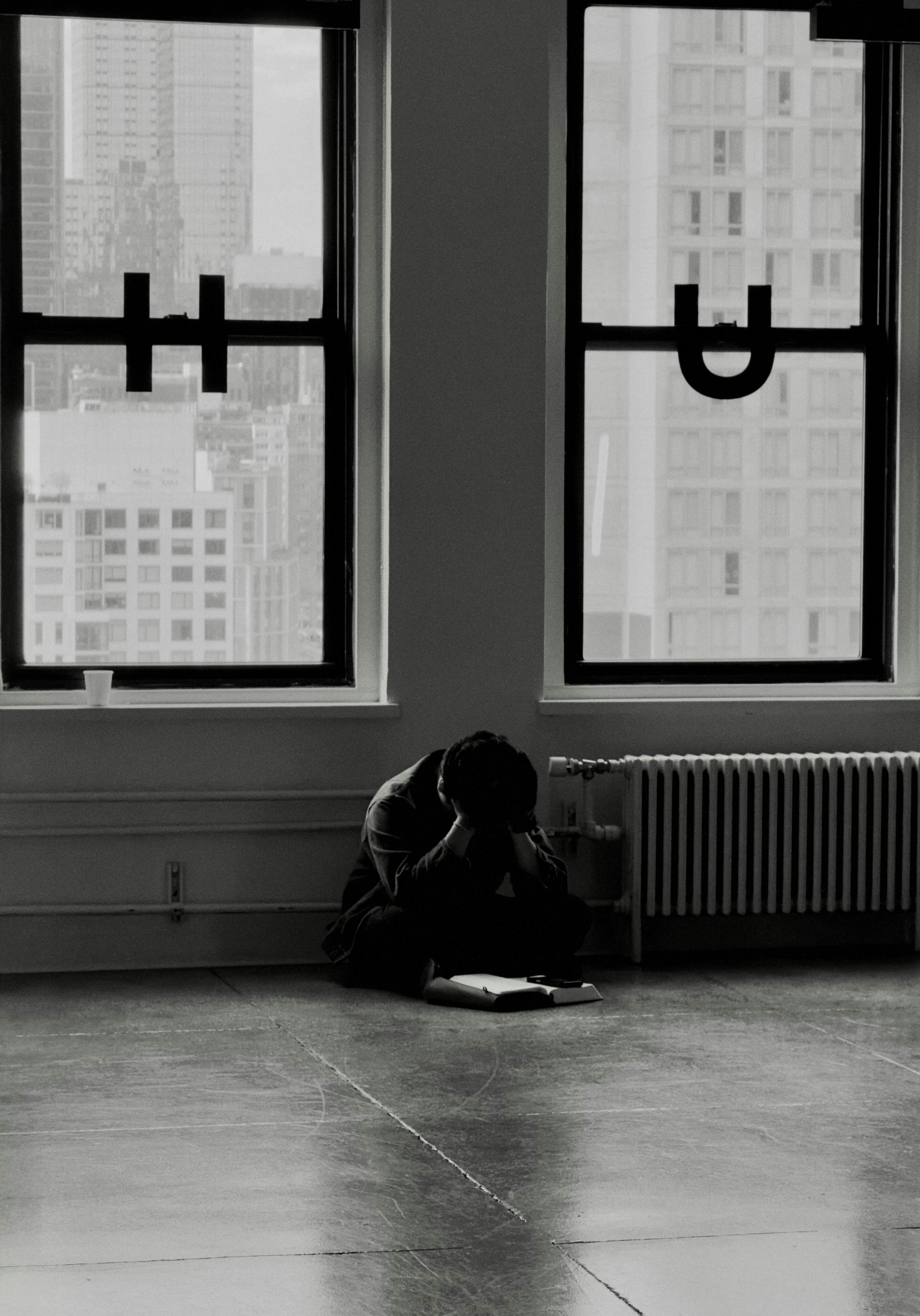 Man sitting on floor with head in hands.