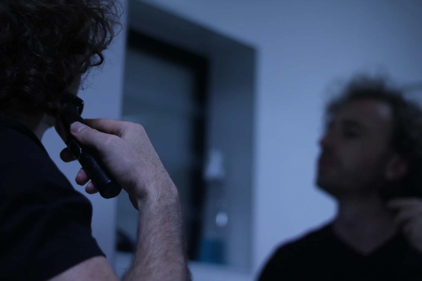 Man using an electric grooming trimmer during a bathroom routine