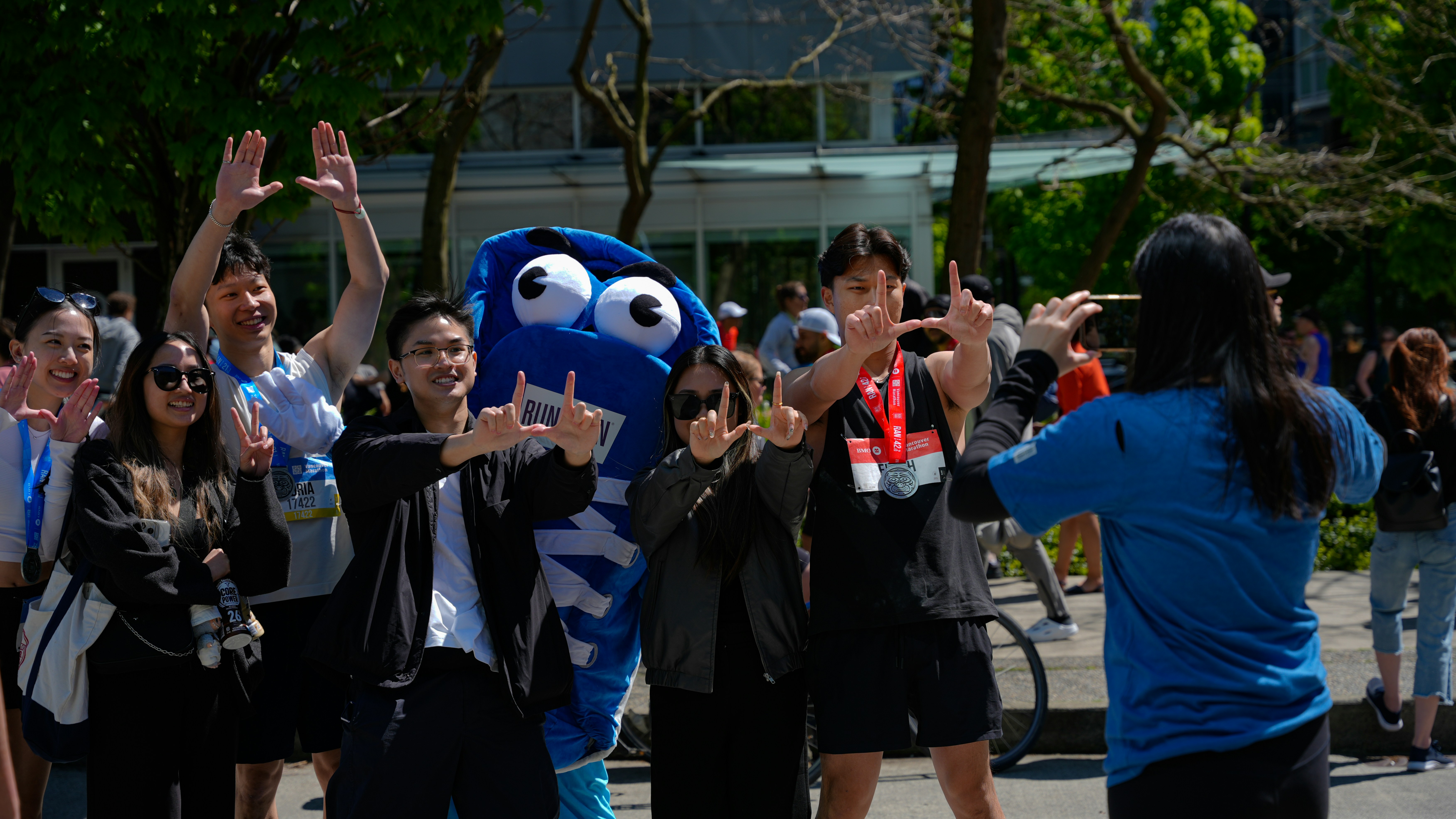 People posing with a blue character costume outdoors