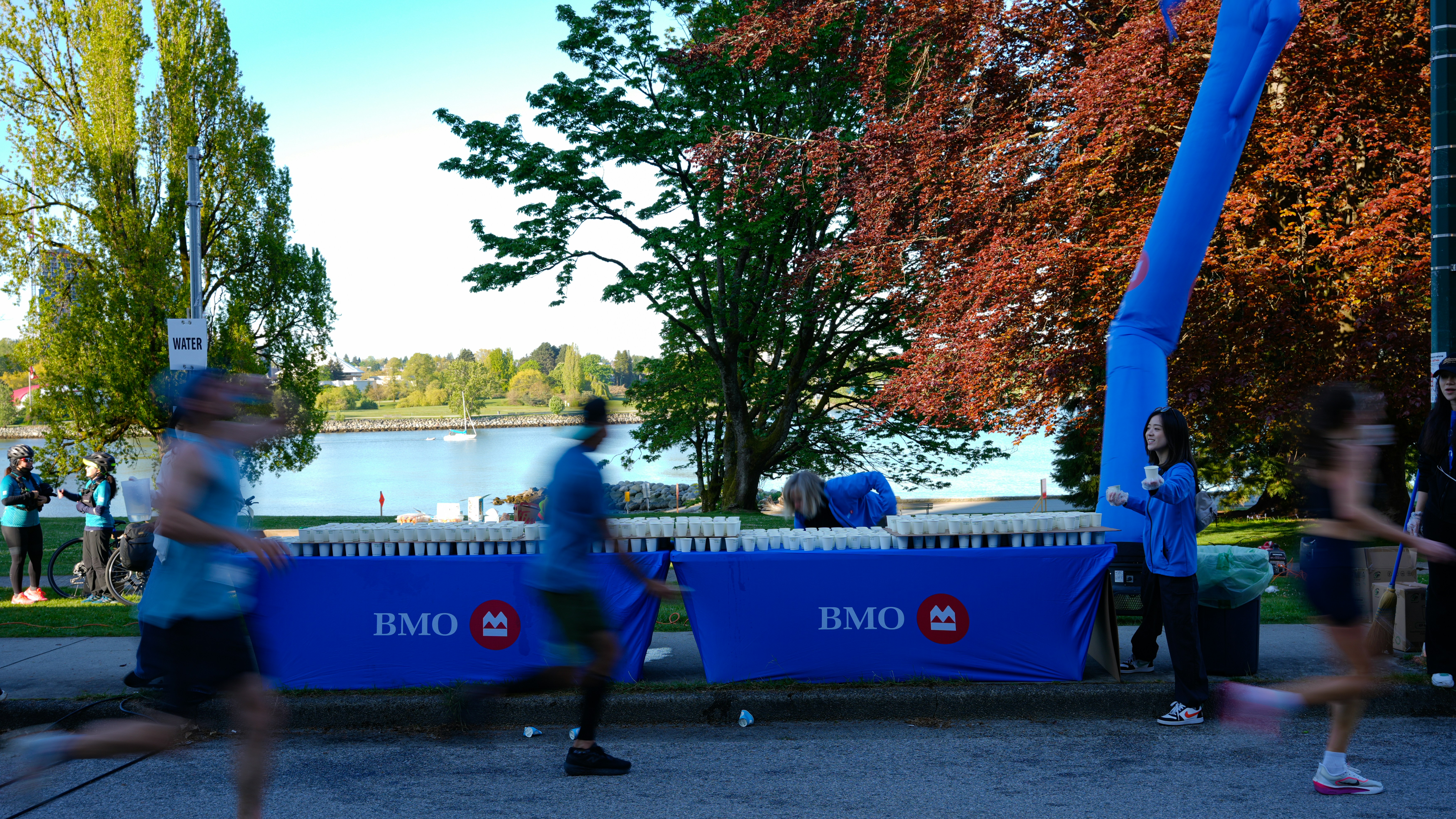 Runners pass bmo banner at outdoor event