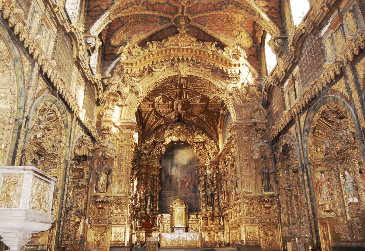 Valletta October — the gilded ornate baroque interior of a Maltese cathedral, cultural season returning as summer heat eases