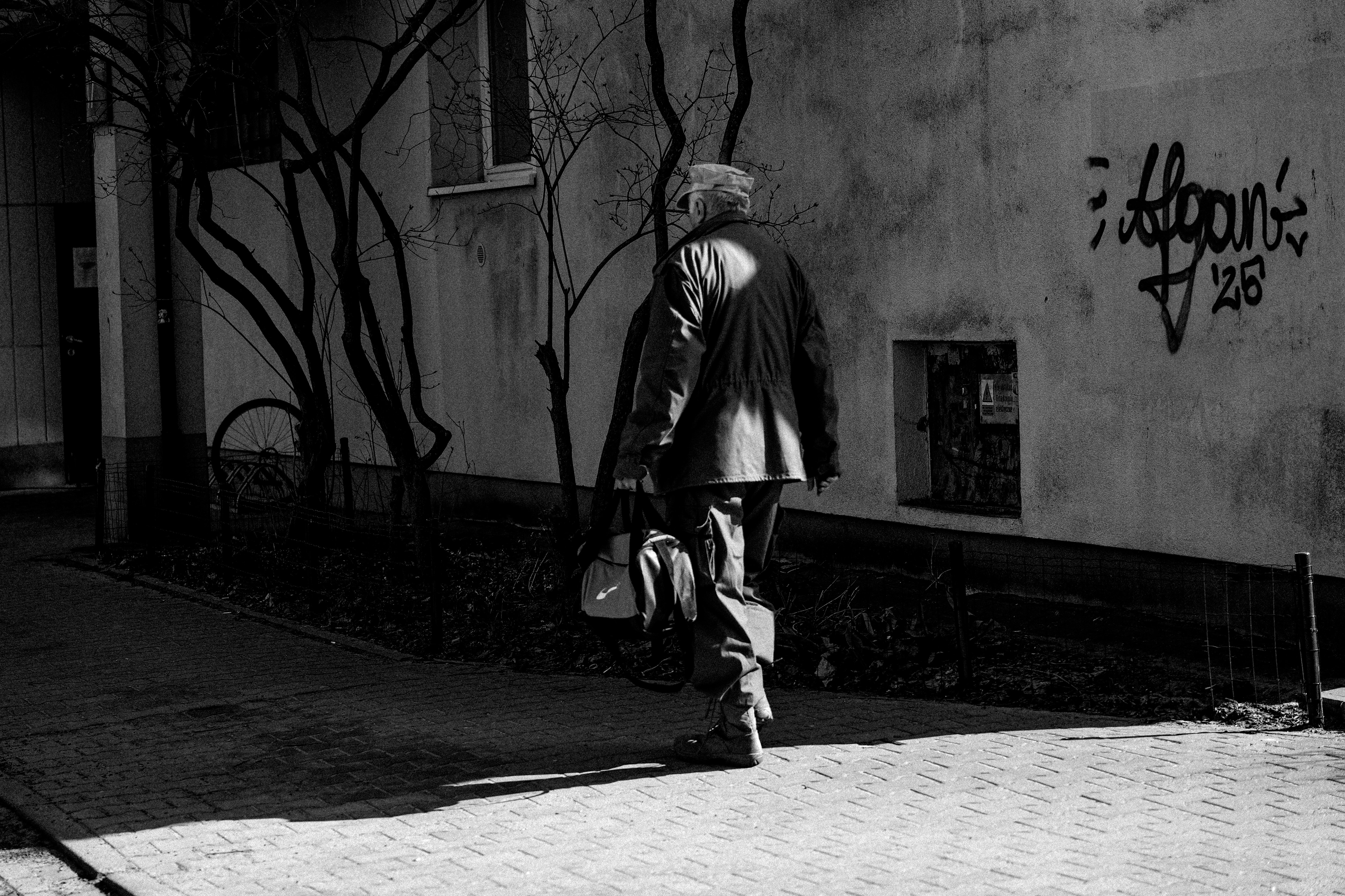 Man walking away from camera with a bag