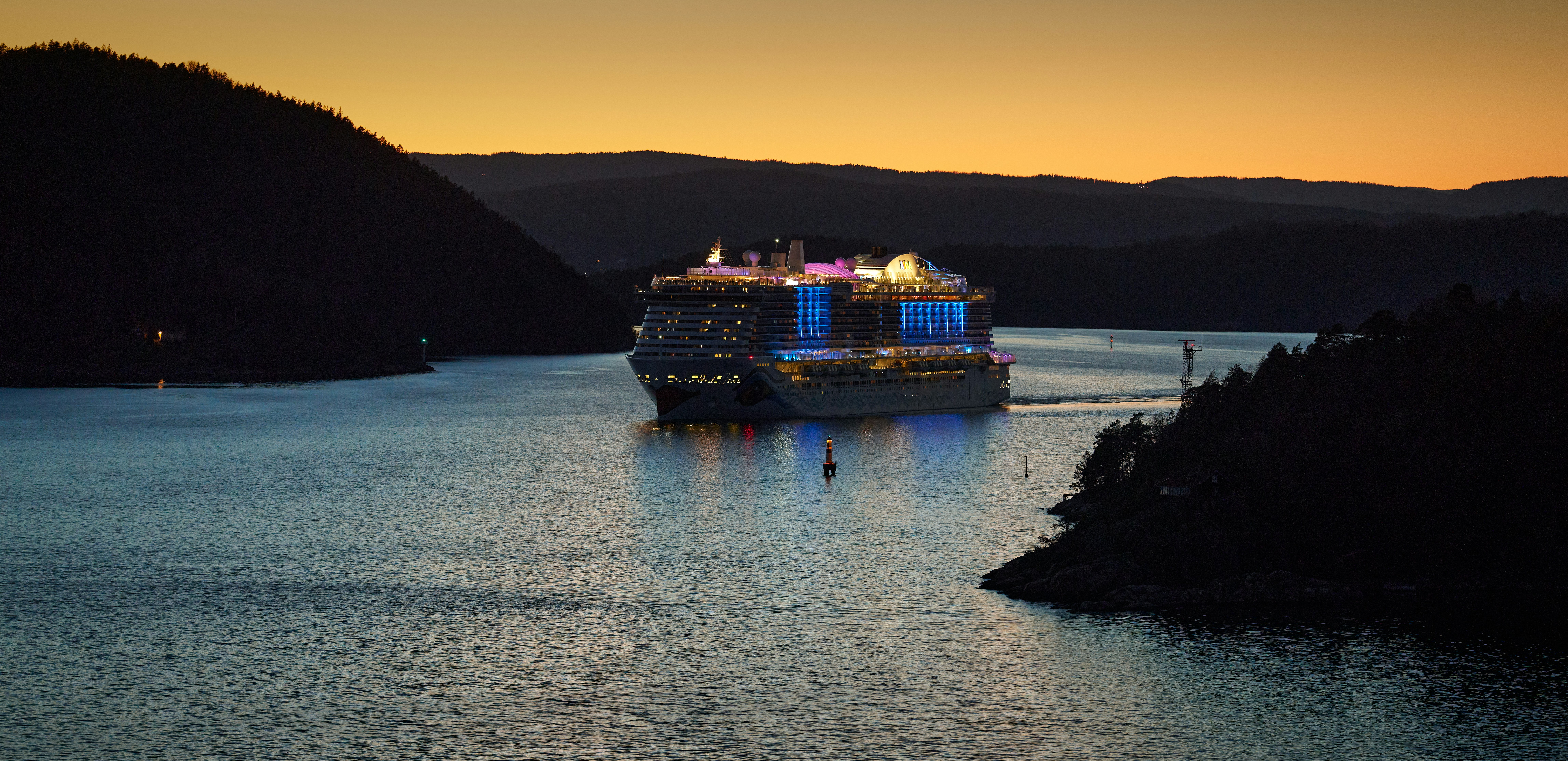 Kreuzfahrtschiff fährt bei Sonnenuntergang auf dem Wasser