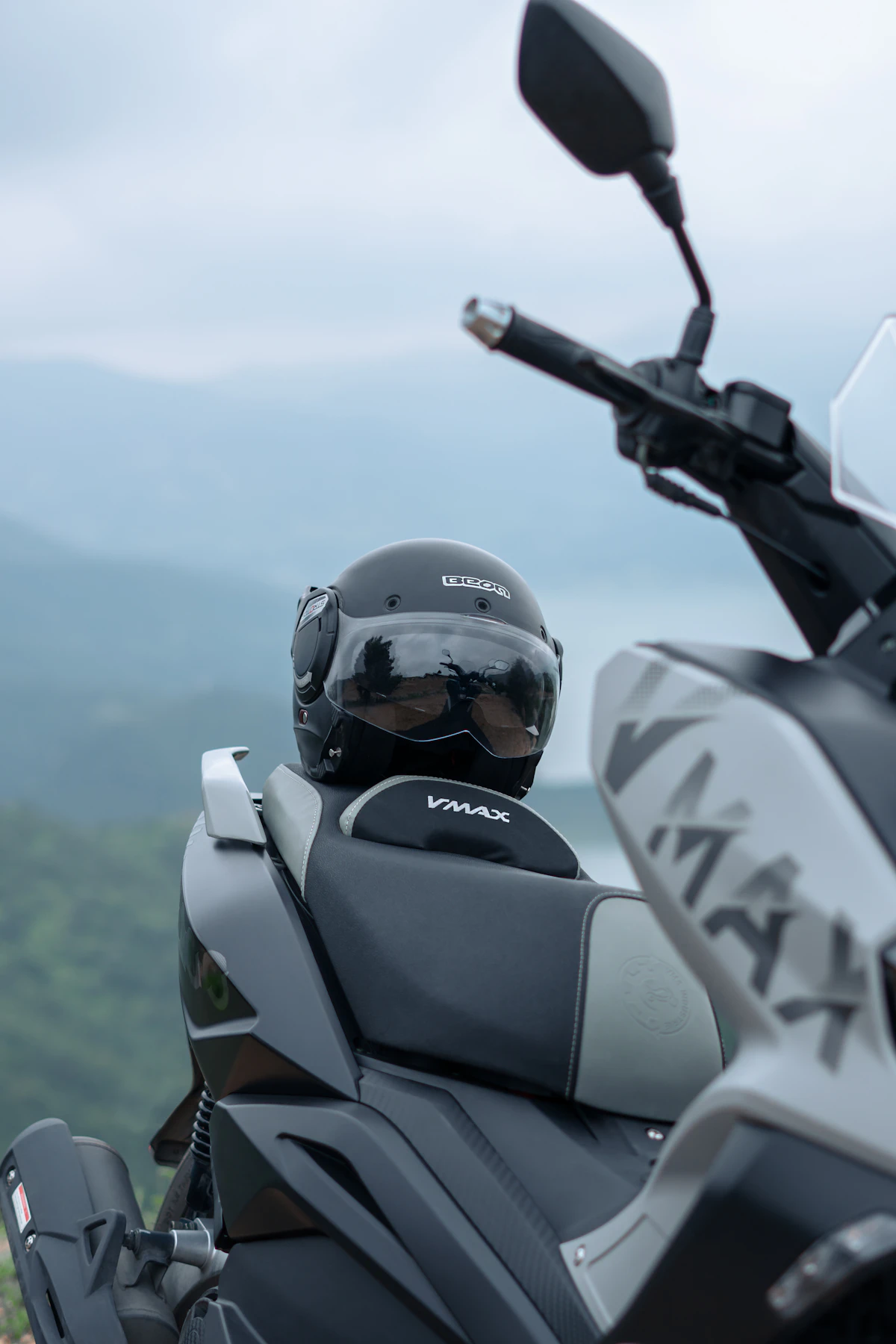 Helm motor diletakkan di atas skuter yang terparkir