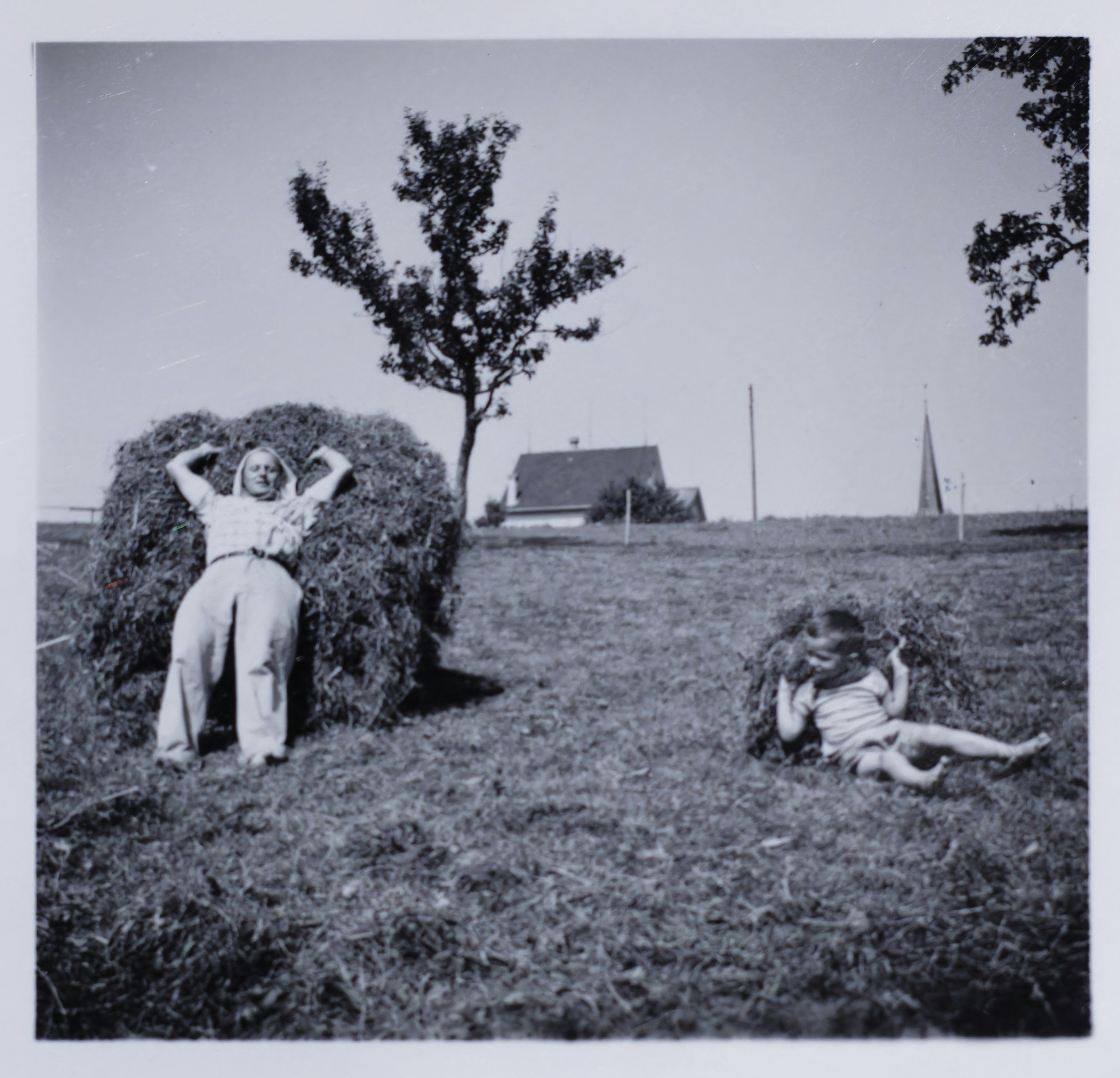 Zwei Personen, die auf Heuballen auf einem Feld entspannen.