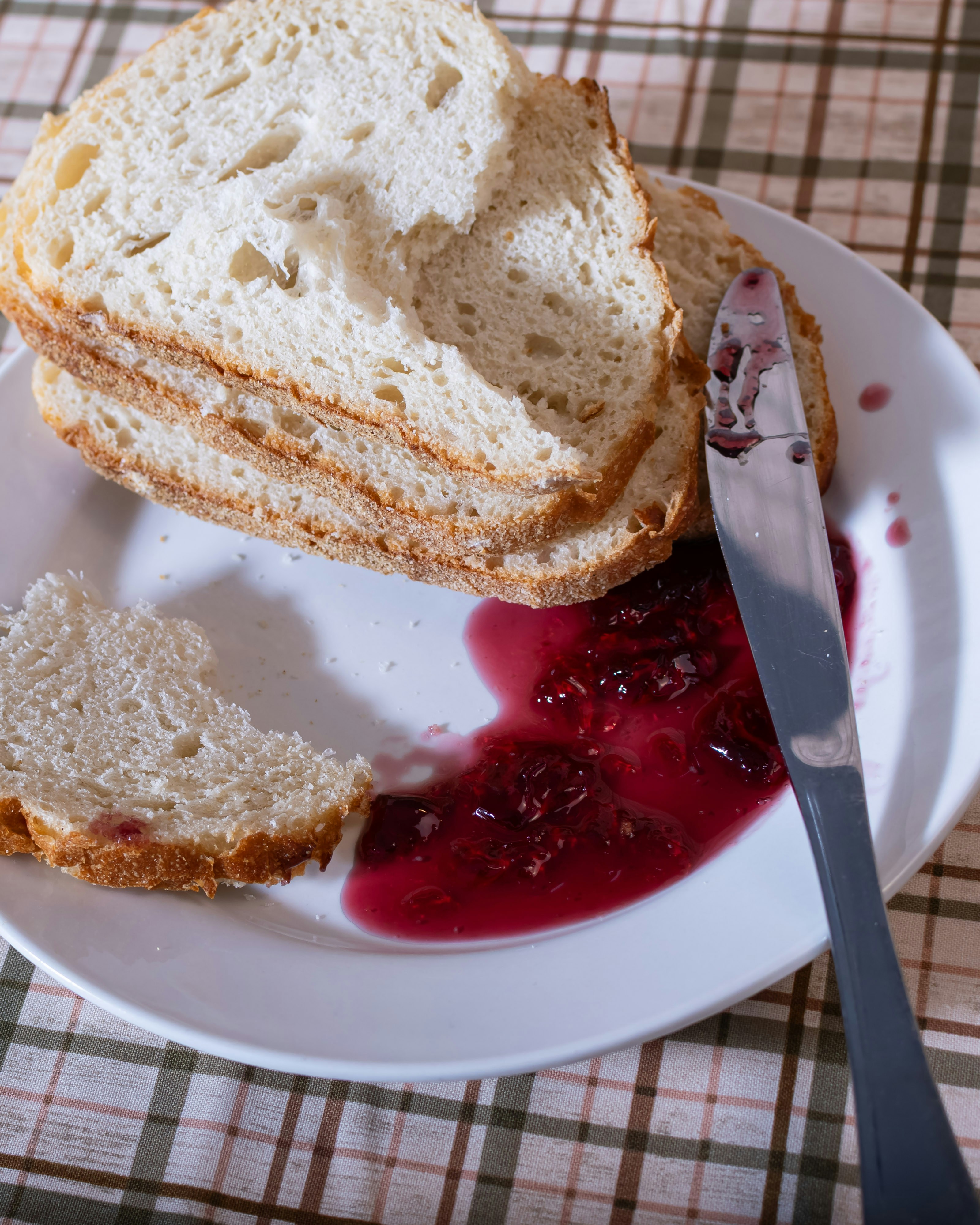 Slices of bread with jam and a knife