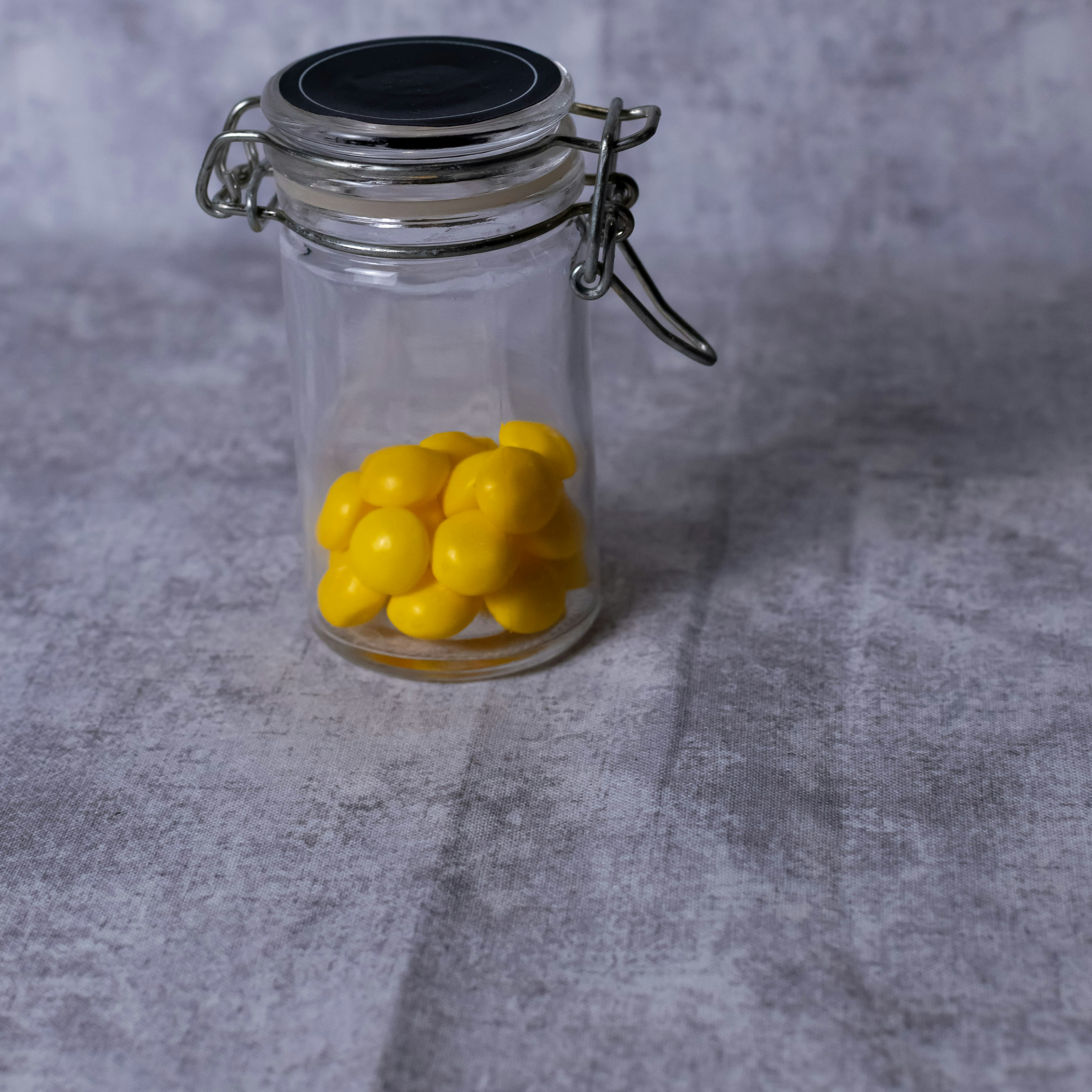 Small glass jar filled with yellow candy