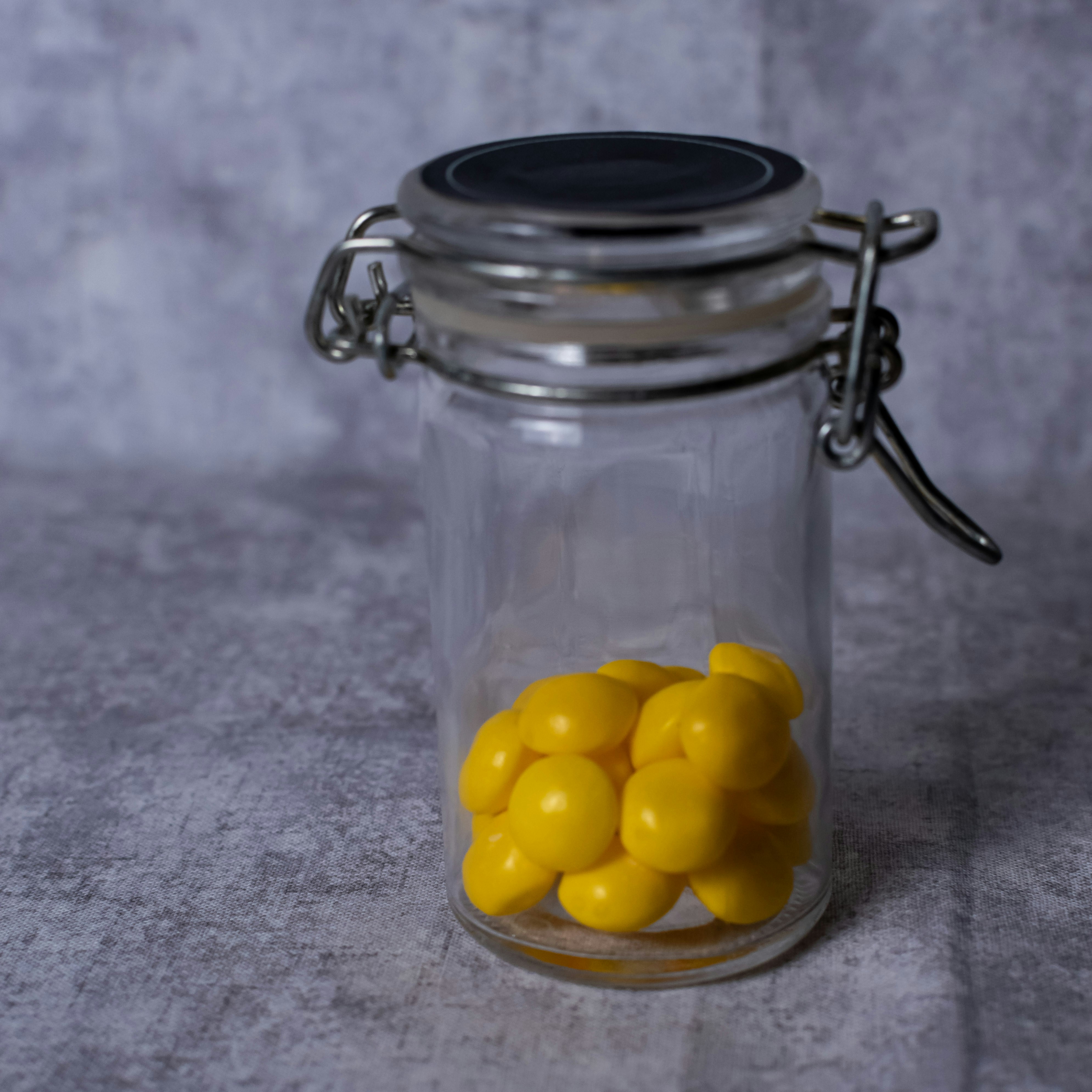 Small glass jar with yellow candies inside