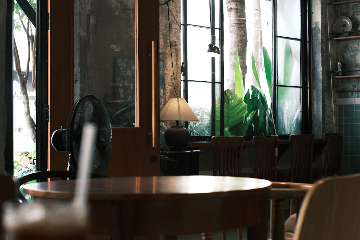 Intérieur de café confortable avec tables en bois et plantes