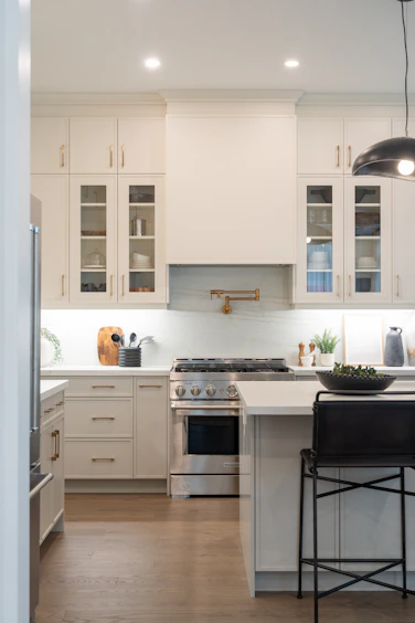 Modern kitchen with white cabinets and stainless steel appliances.