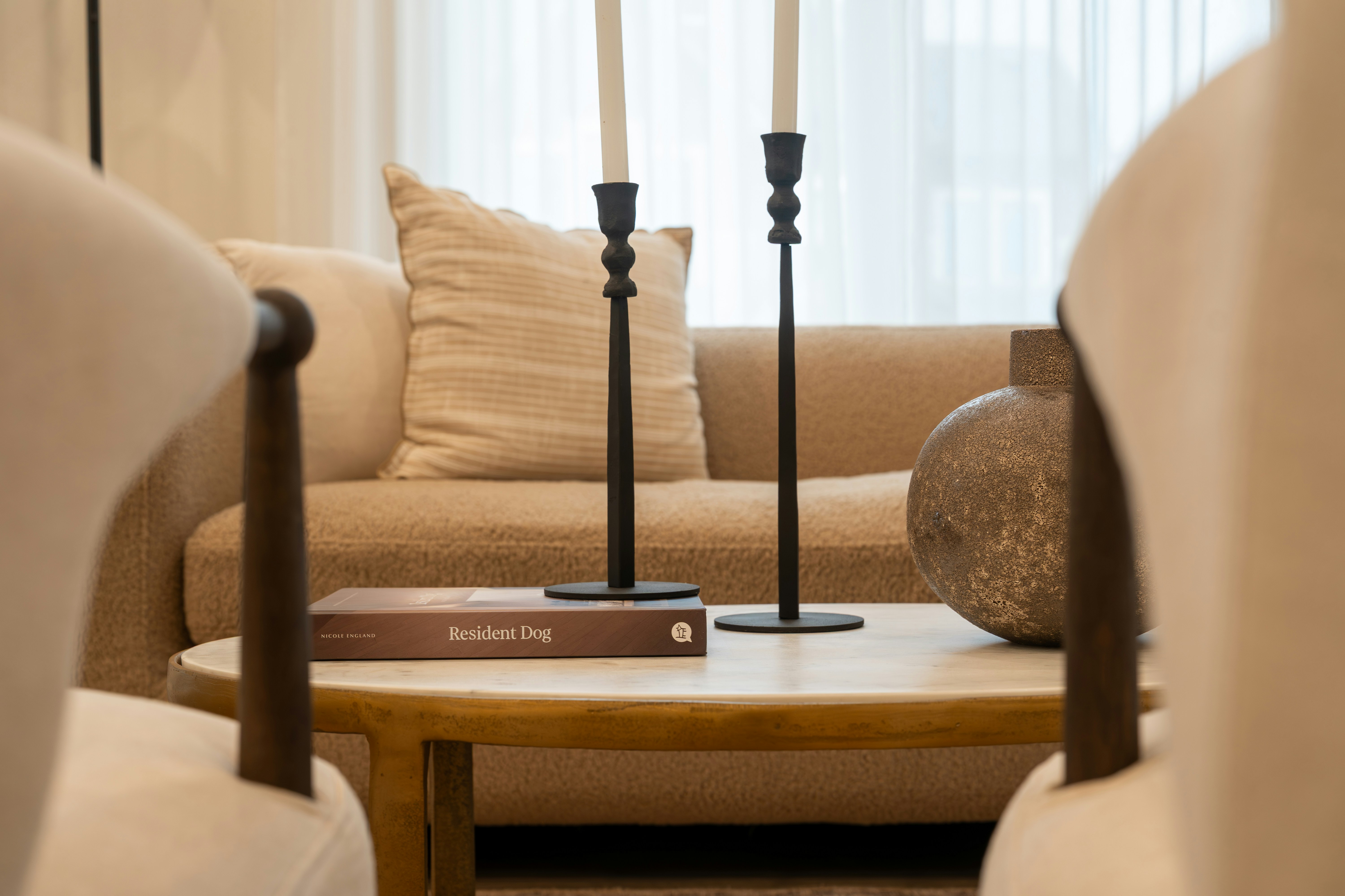 Two candlesticks on a coffee table with a book.