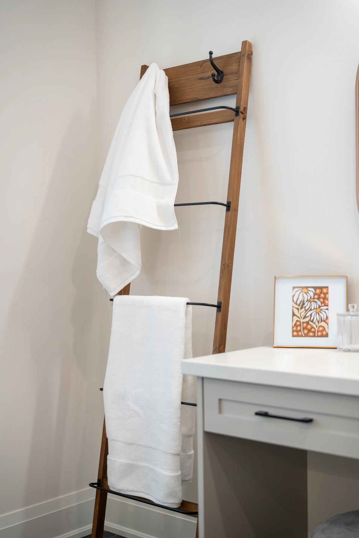 Wooden towel ladder holding towels in a small cozy bathroom