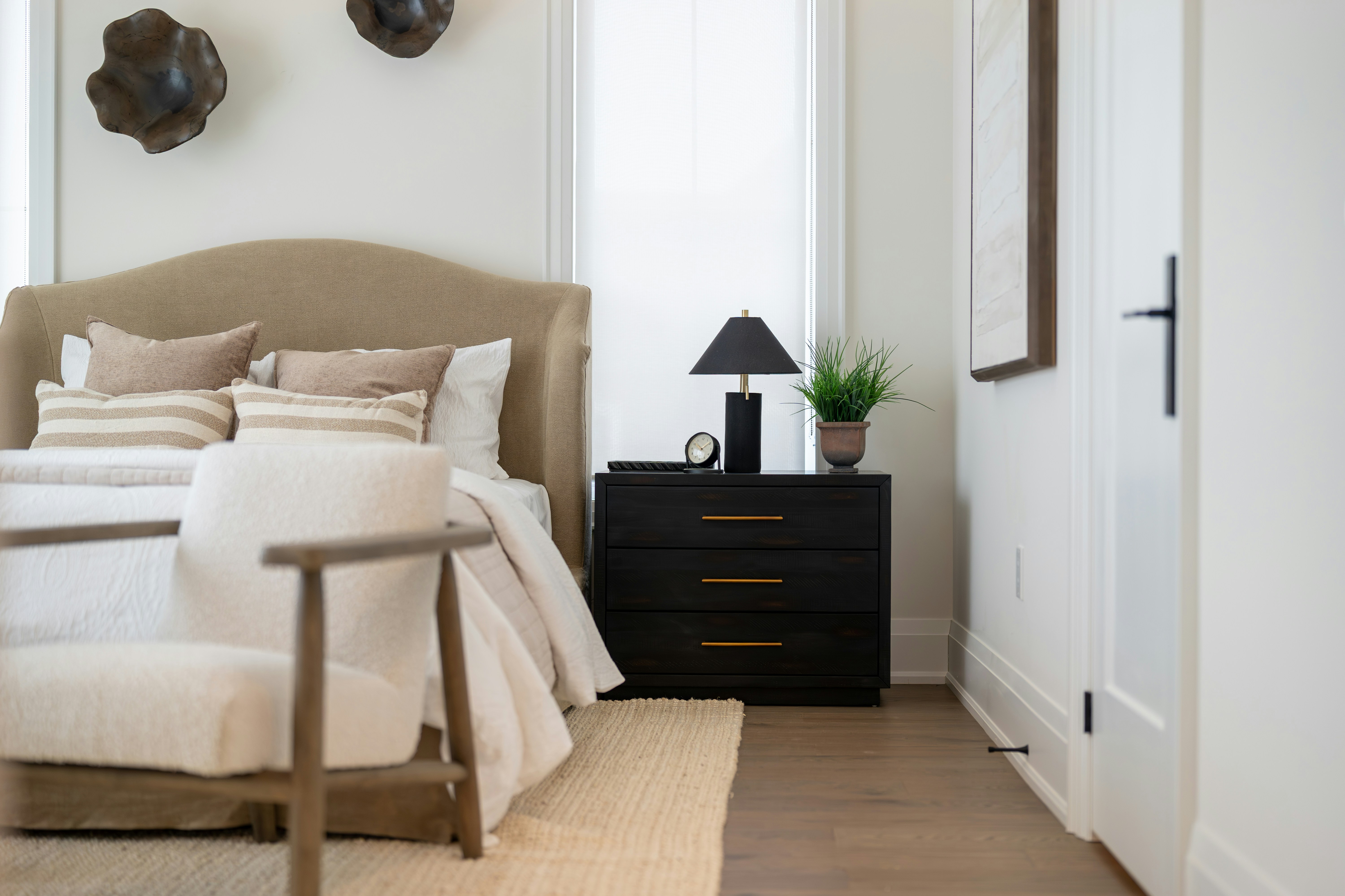 A modern bedroom with a tufted headboard and nightstand.