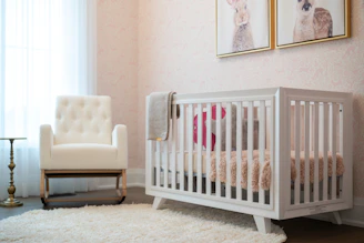 A cozy nursery with a white crib and armchair.