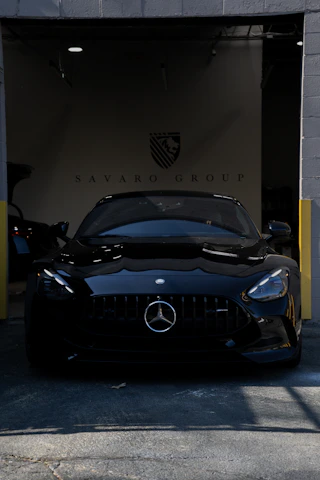 A sleek black mercedes-benz sports car parked inside a garage.