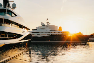 Two luxury yachts docked at sunset