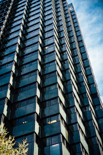 Modern skyscraper with reflective glass windows against blue sky