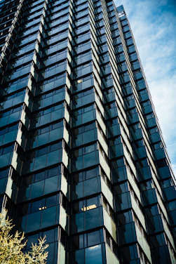 Modern skyscraper with reflective glass windows against blue sky