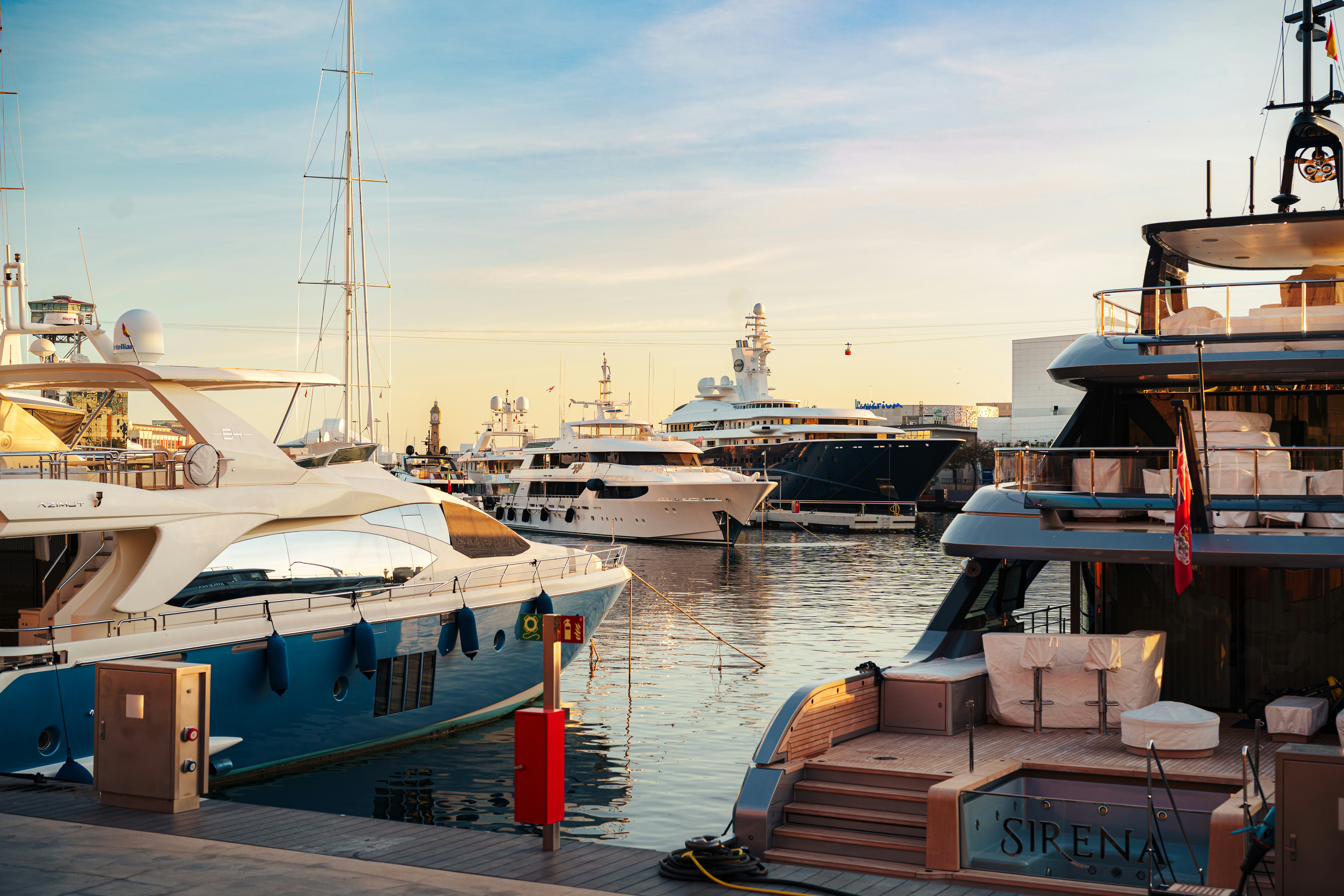 Yates de lujo atracados en un puerto soleado.