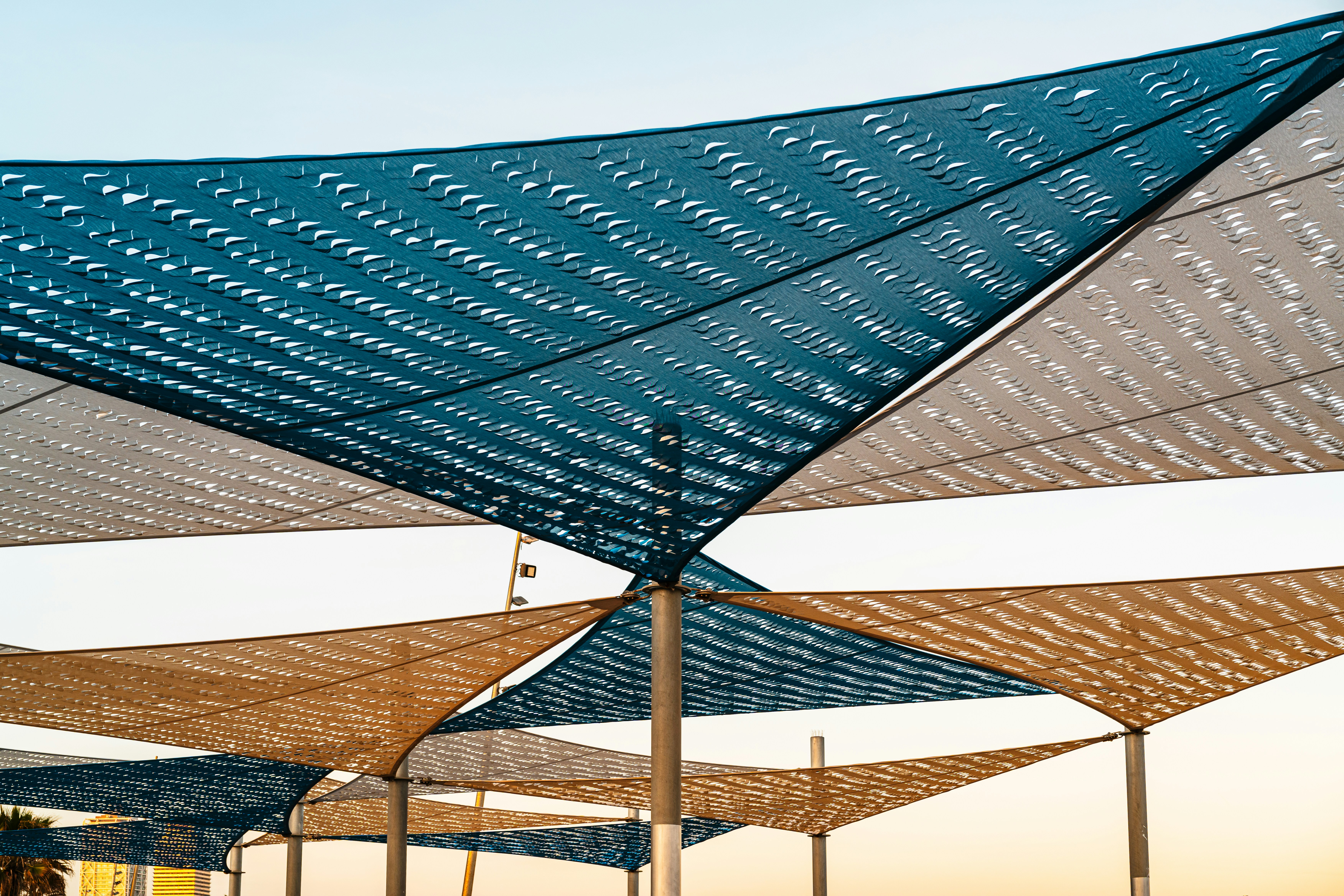 Triangular shade sails creating geometric patterns