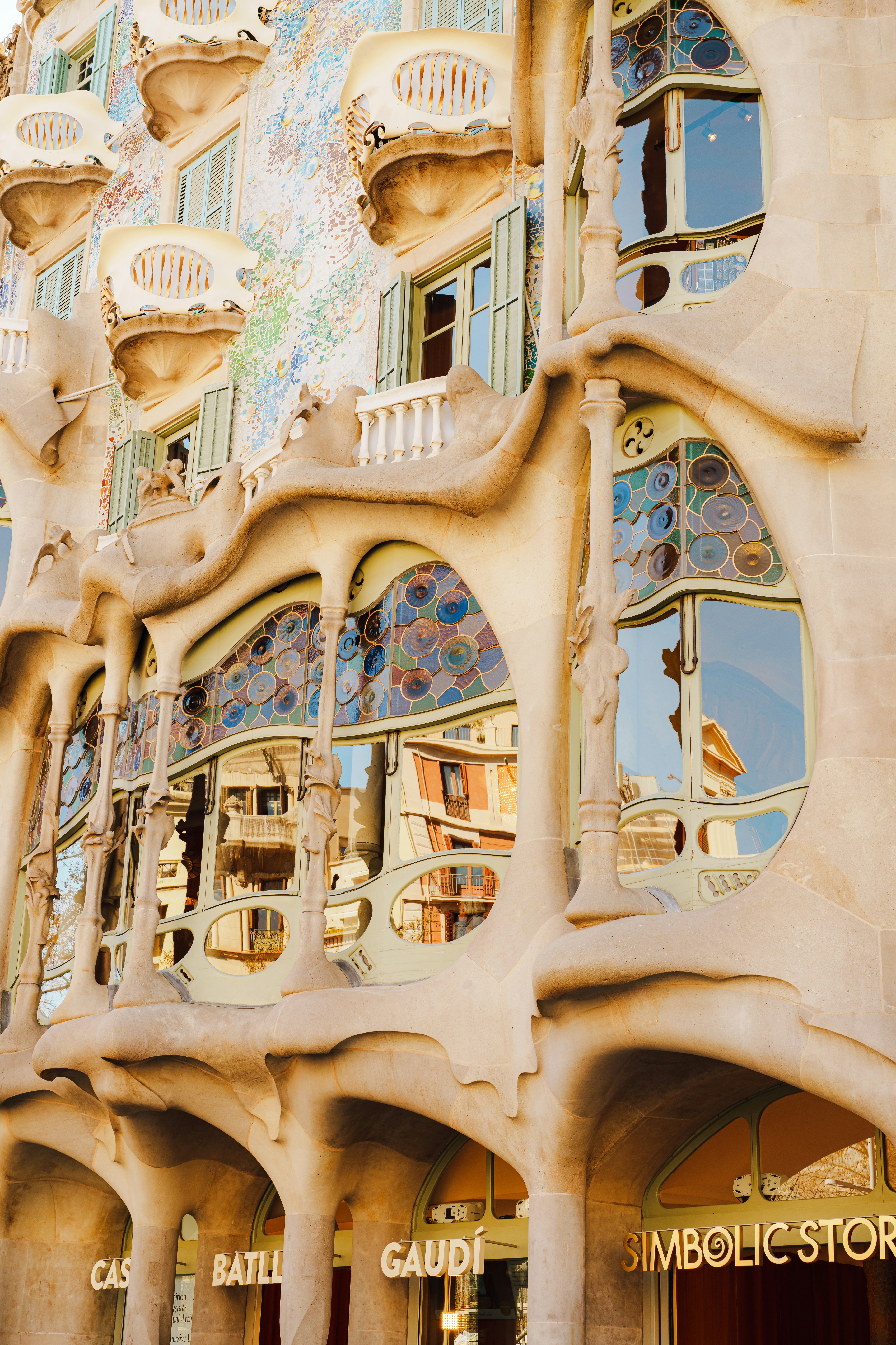 Fasad berornamen Casa Batlló dengan jendela kaca patri berwarna-warni