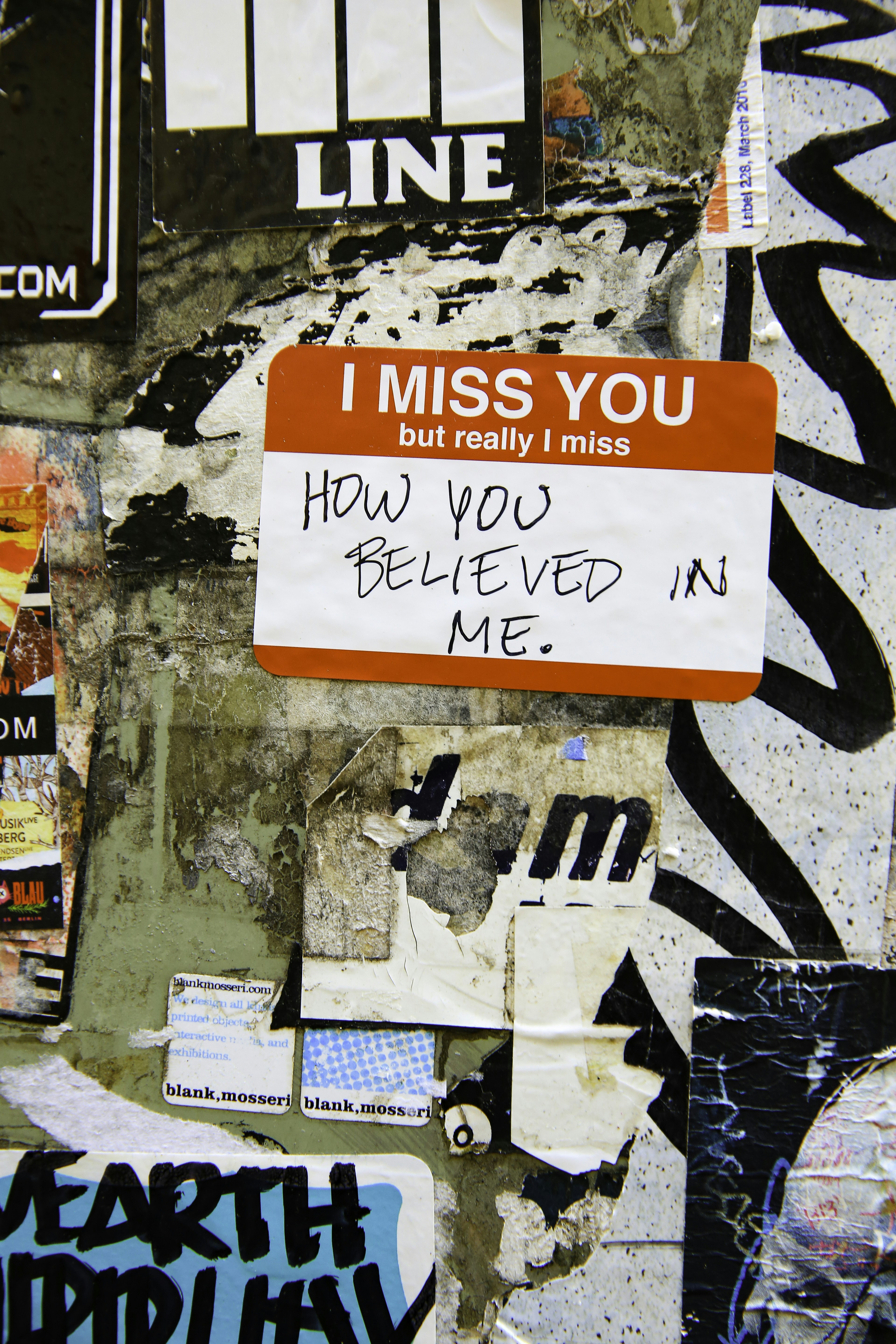 Red sticker with text "i miss you" on wall