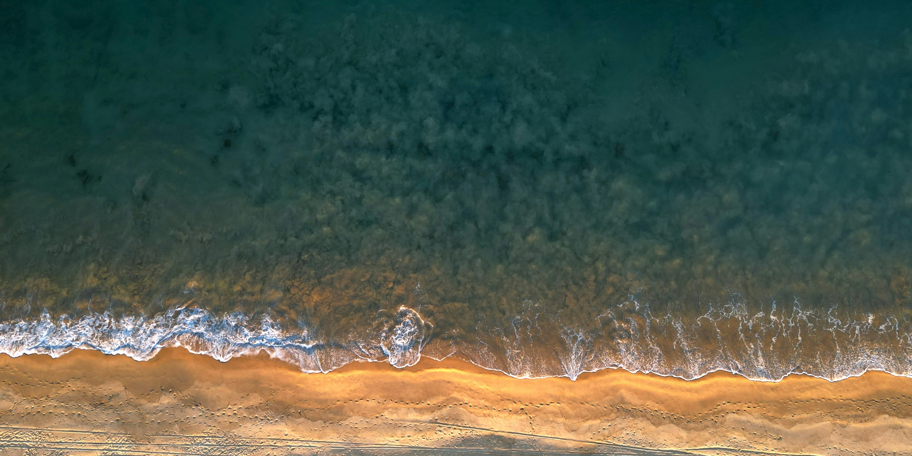 Vue aérienne des vagues s’écrasant sur une plage de sable