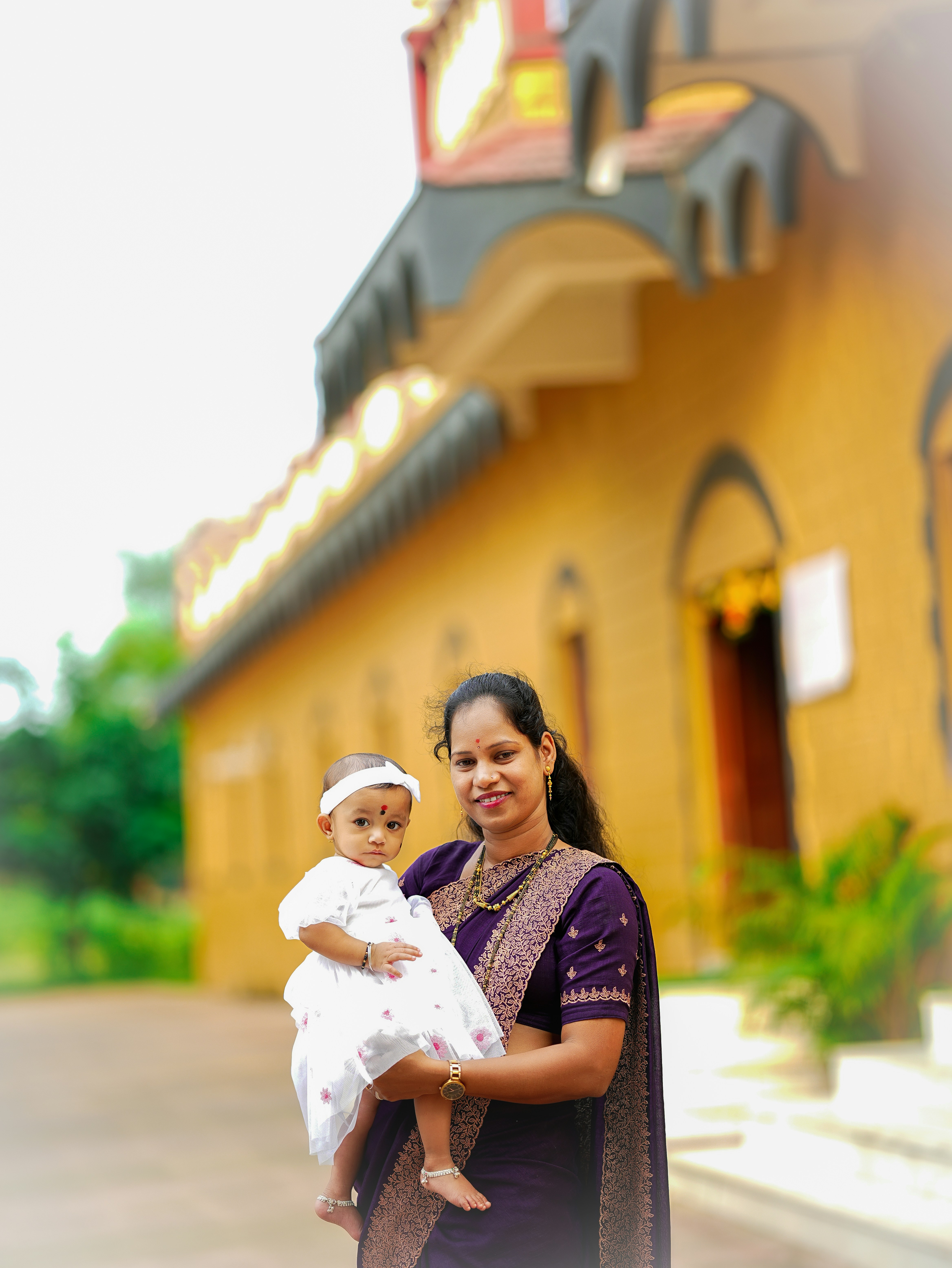 Ibu menggendong bayi di depan gedung