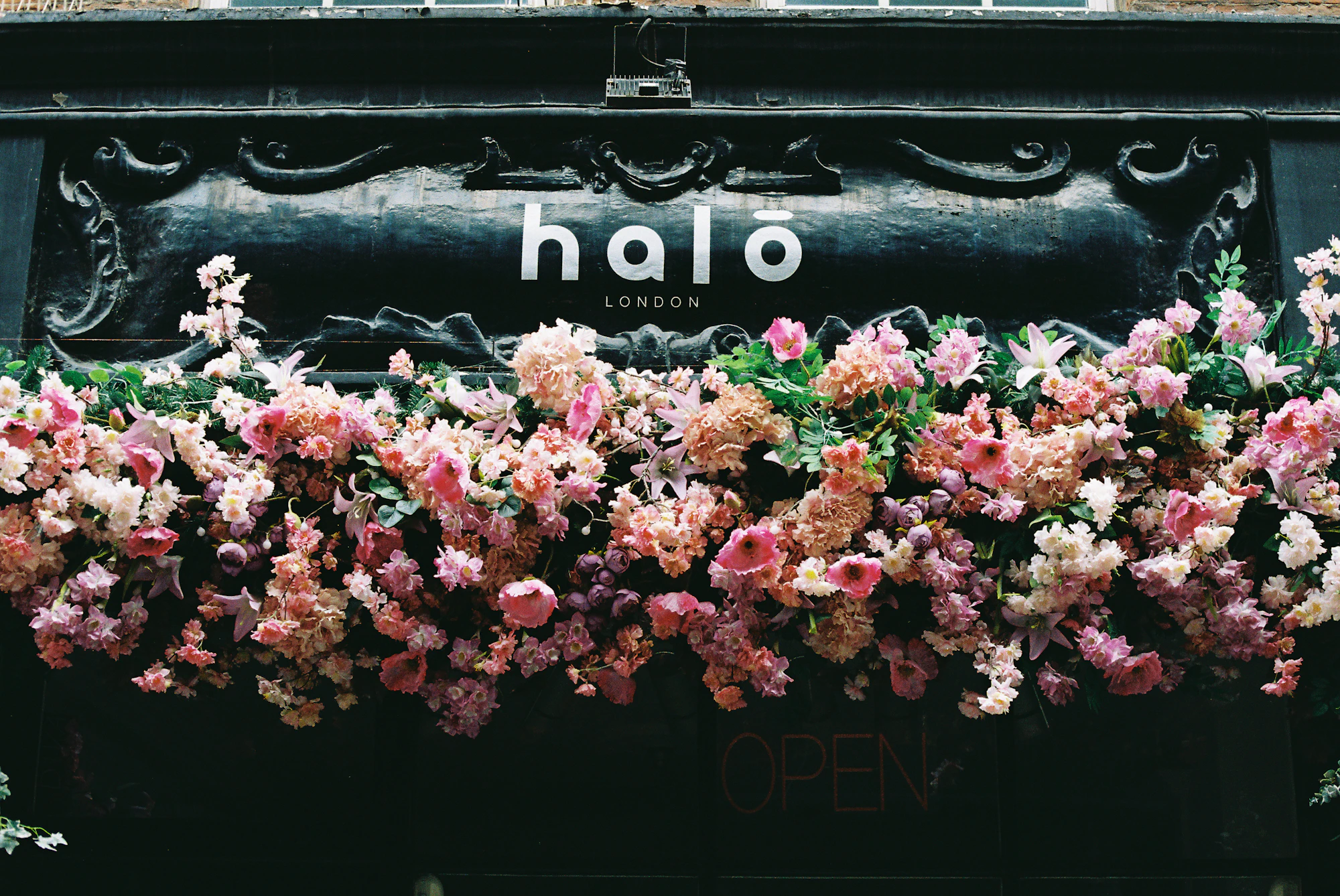 Storefront sign with a lush floral arrangement