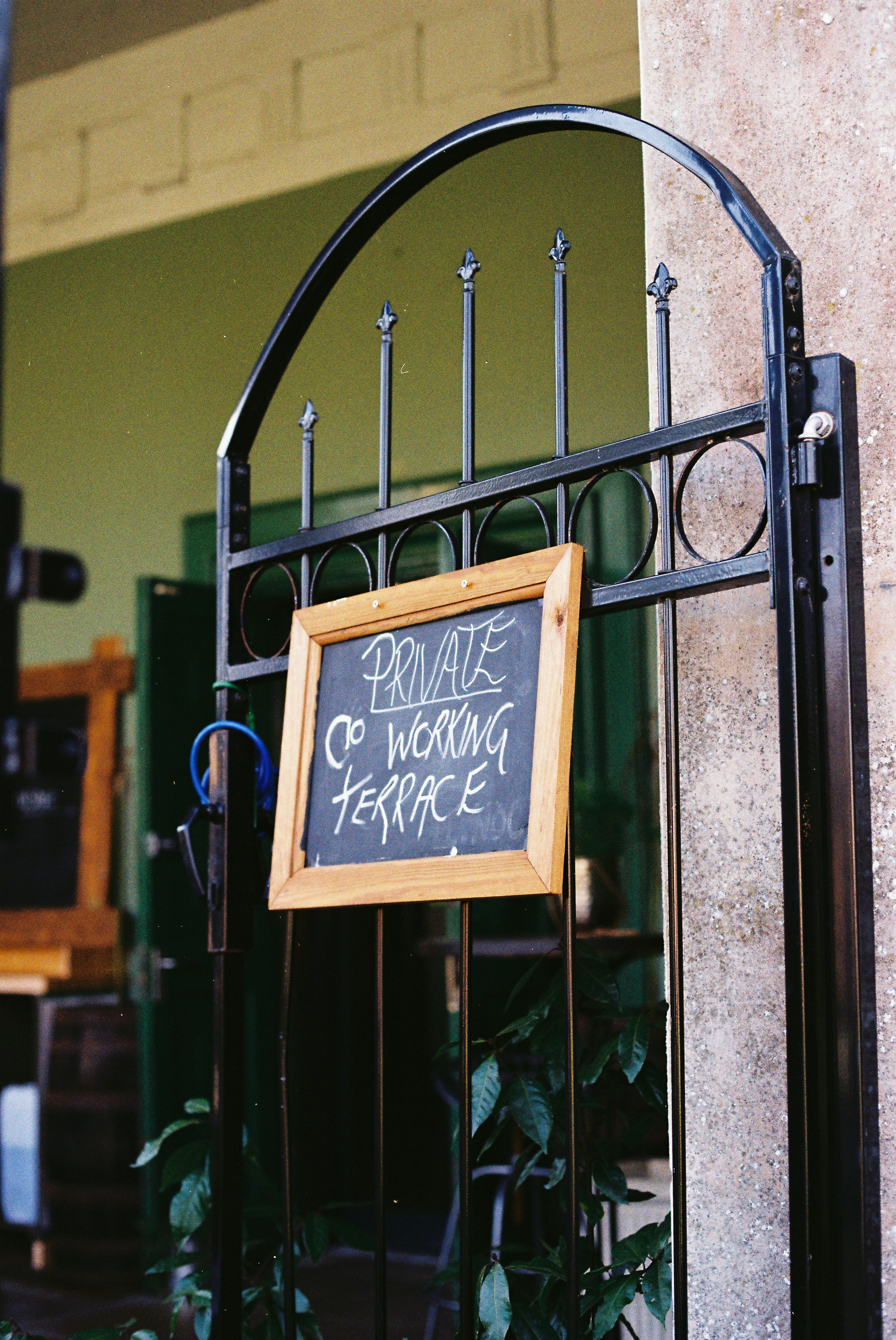 Chalkboard sign on a gate reads private co working terrace