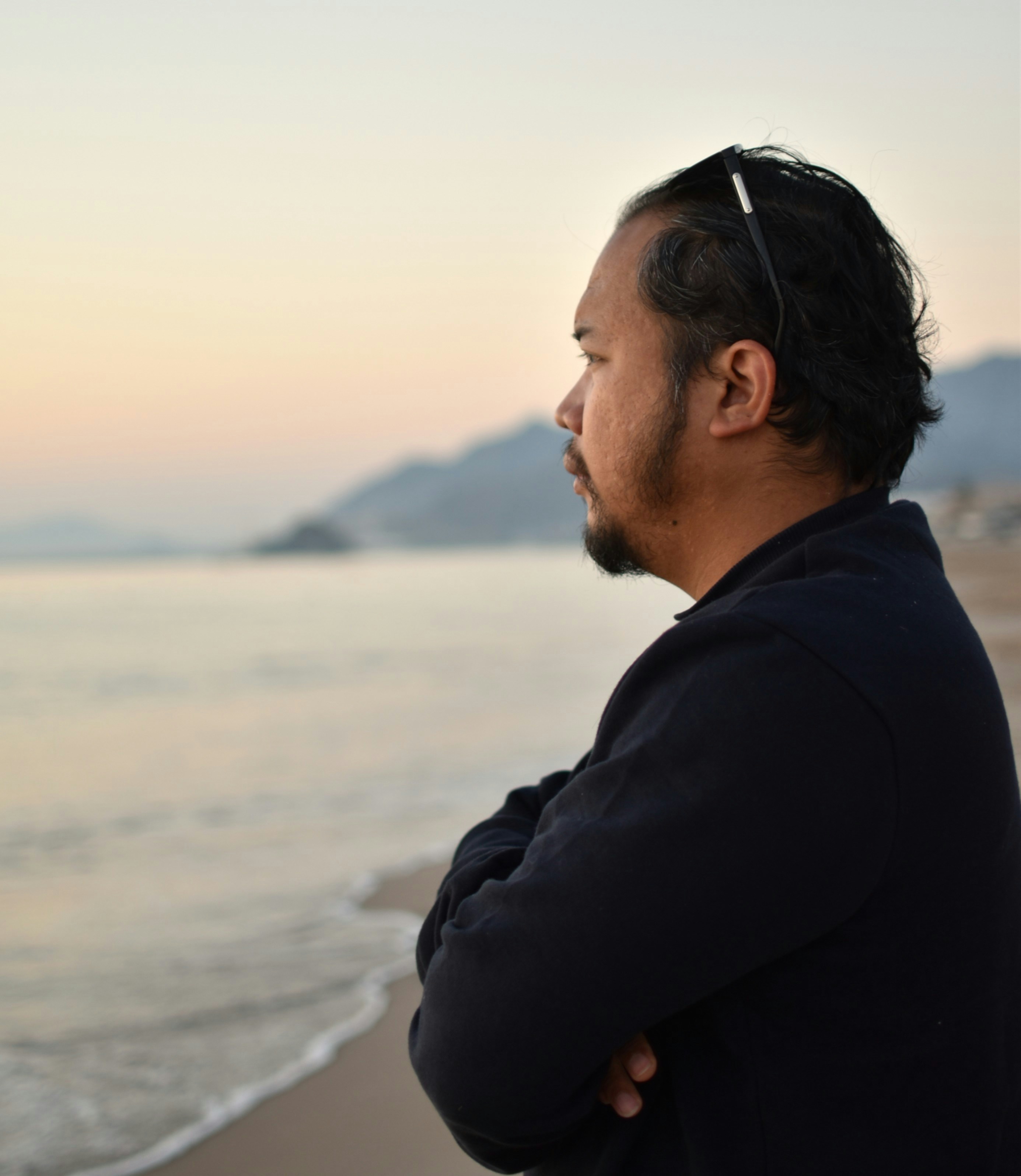 Man looking out at the ocean at sunset