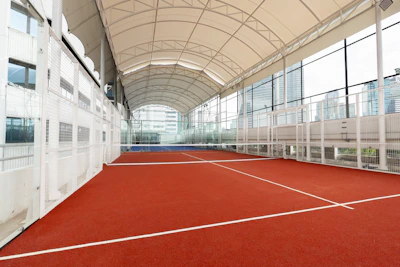 Indoor tennis court with red surface and white lines