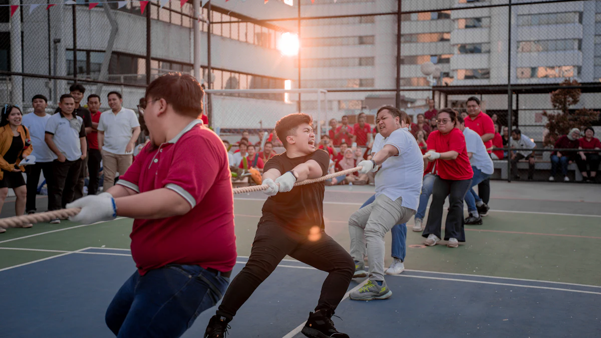 Colleagues pulling a rope in a tug-of-war on an outdoor sports court