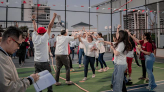 People celebrating outdoors with raised arms.