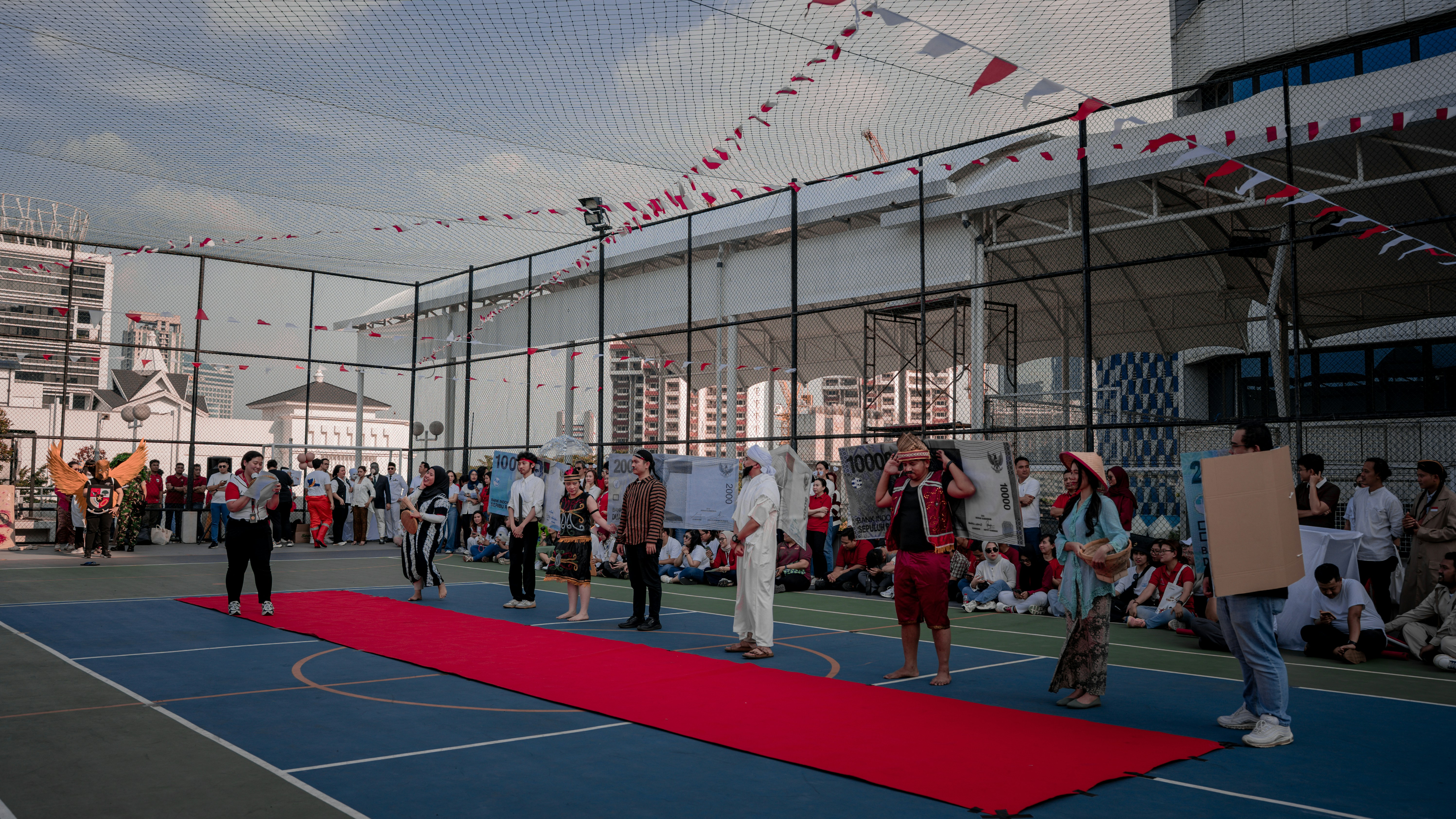 People gathered for an outdoor event with a red carpet.