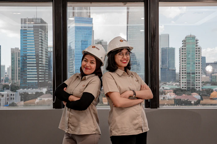 Two women in hard hats in an office