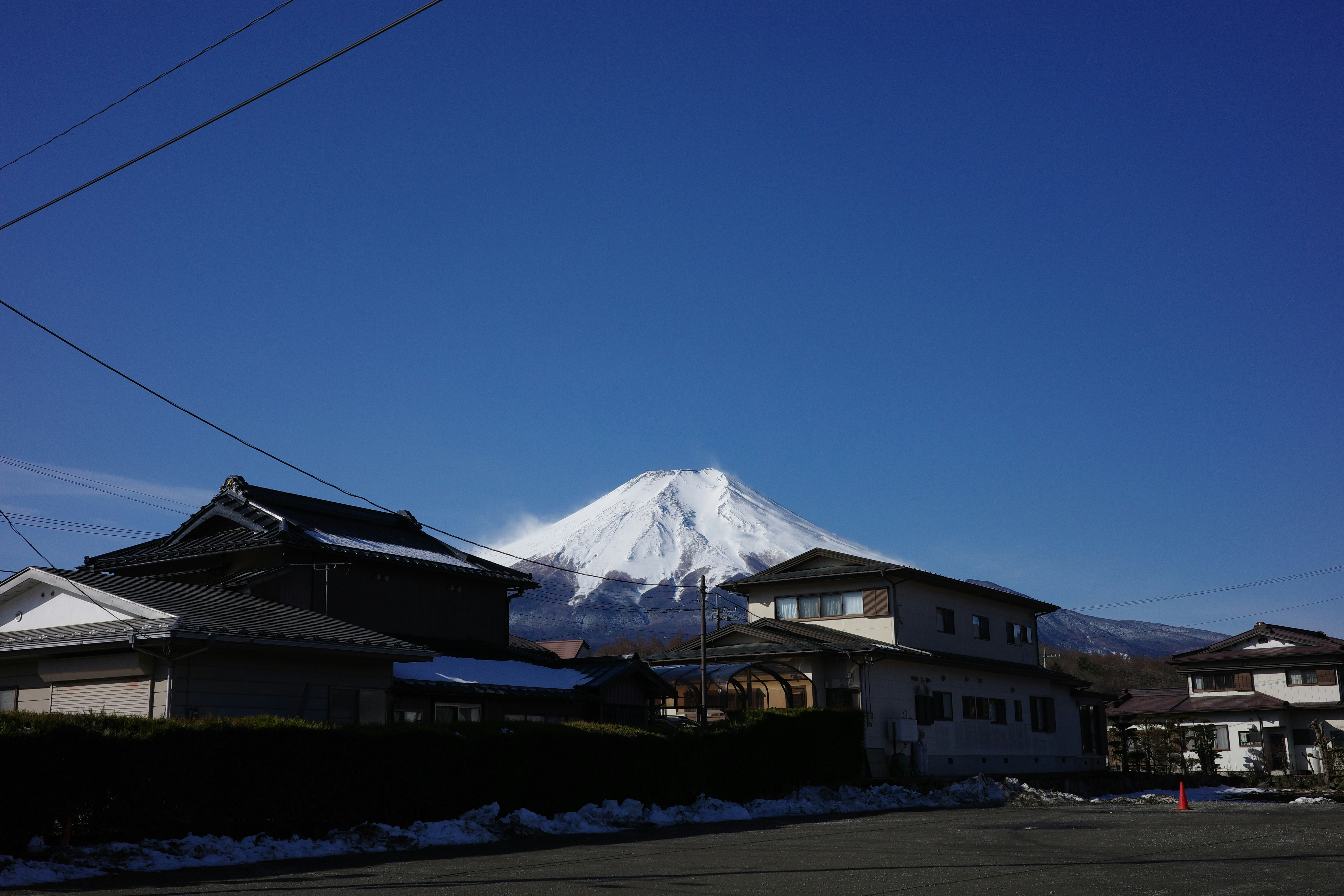 Snow-capped mount fuji rises above a japanese village.